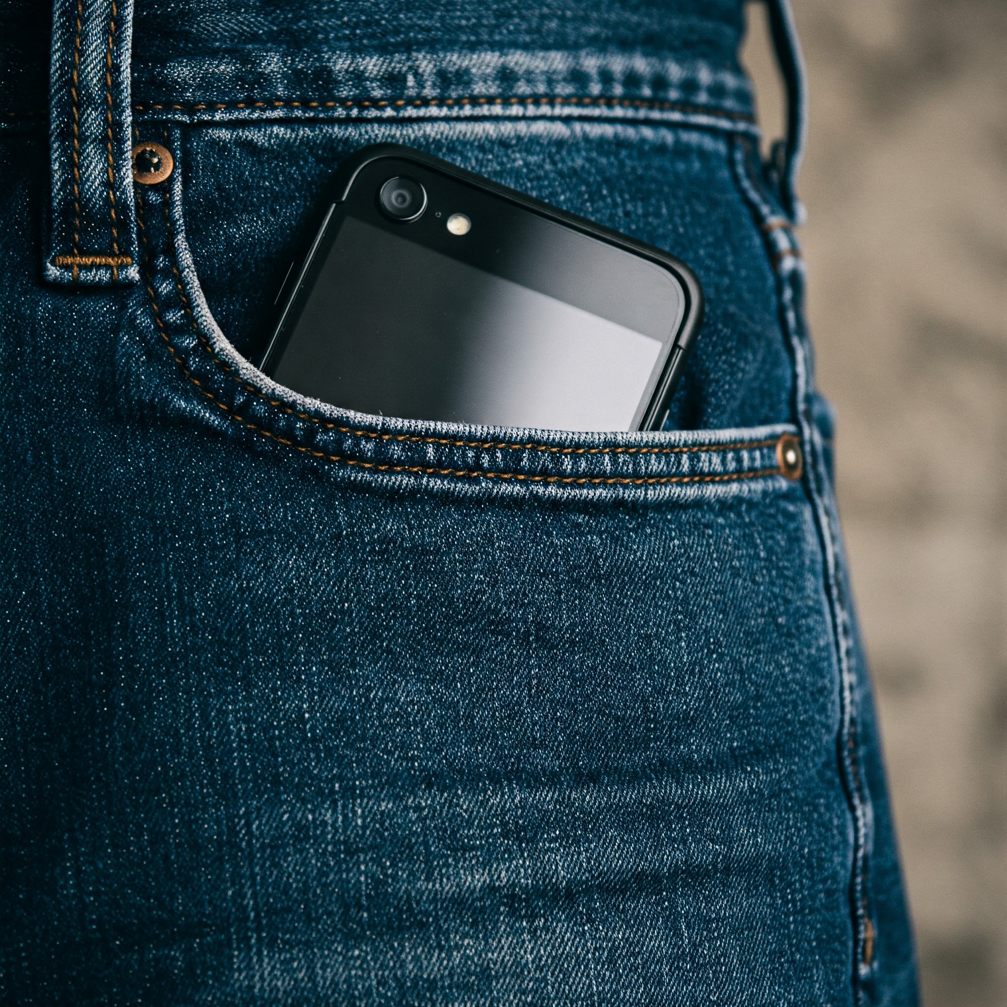 Un téléphone portable dans la poche de jean d'un homme | Source : Gemini