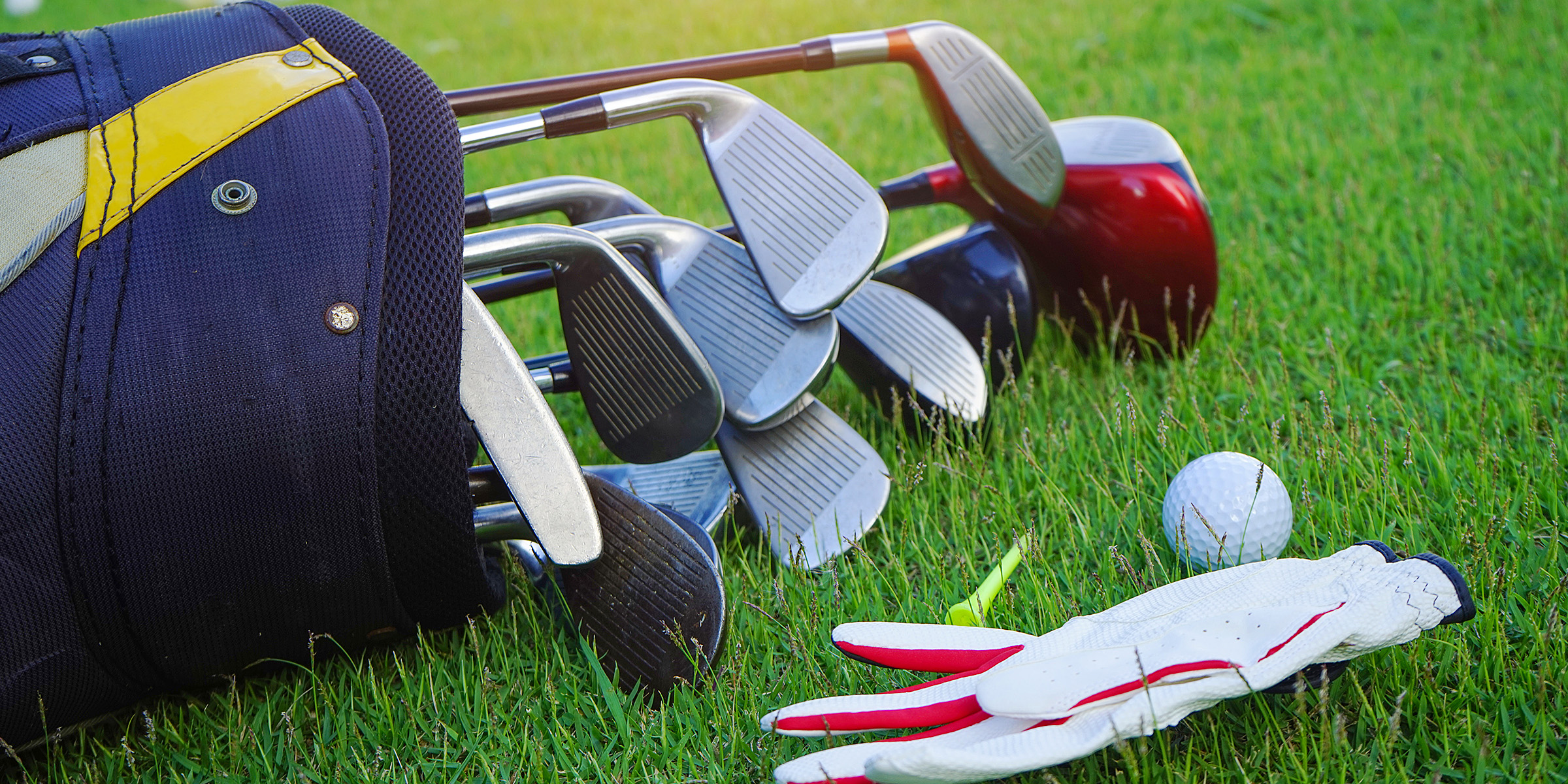 Un kit de clubs de golf et une balle de golf posés sur l'herbe | Source : Shutterstock