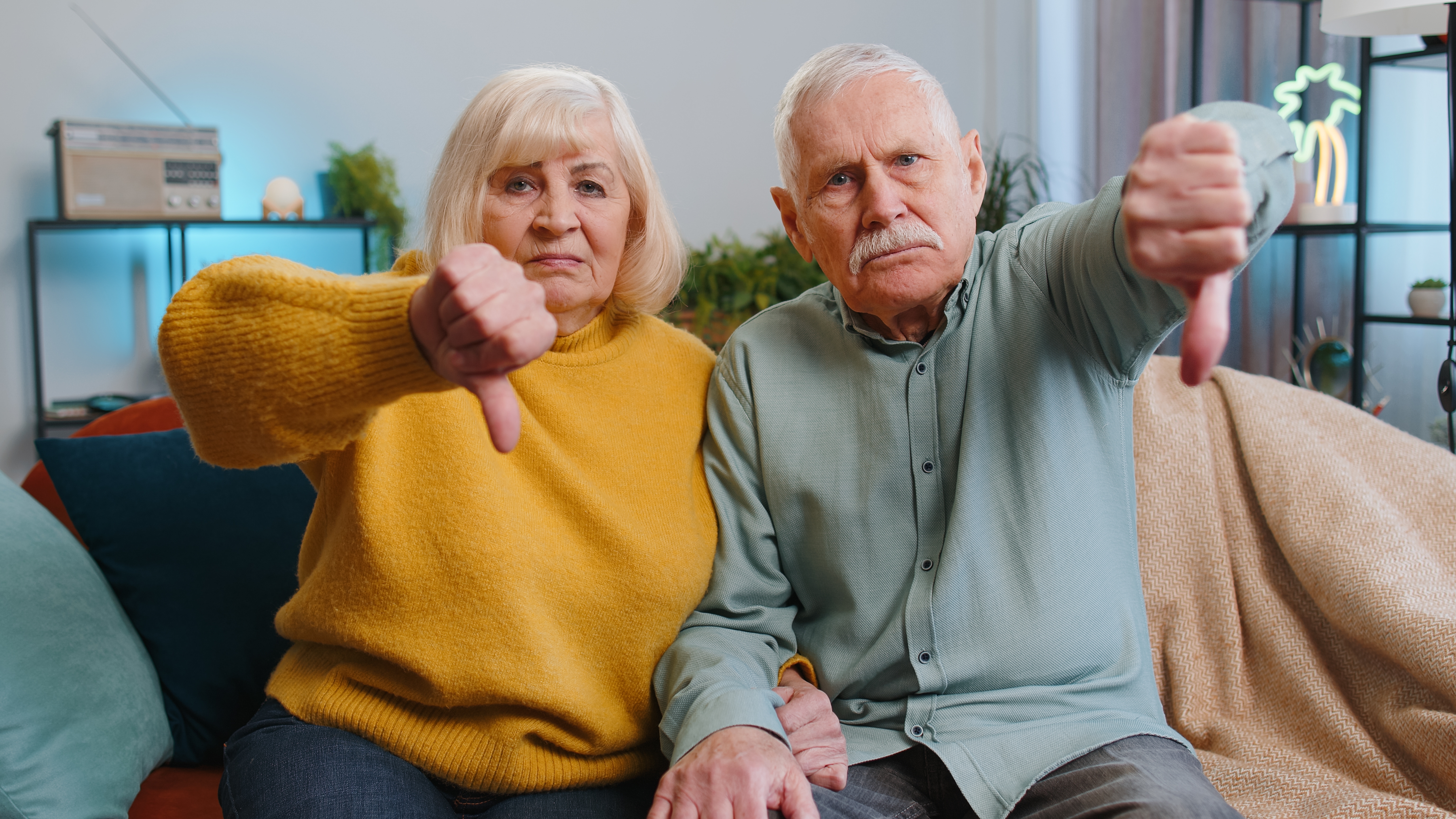 Un couple de seniors montrant le signe du pouce vers le bas | Source : Shutterstock