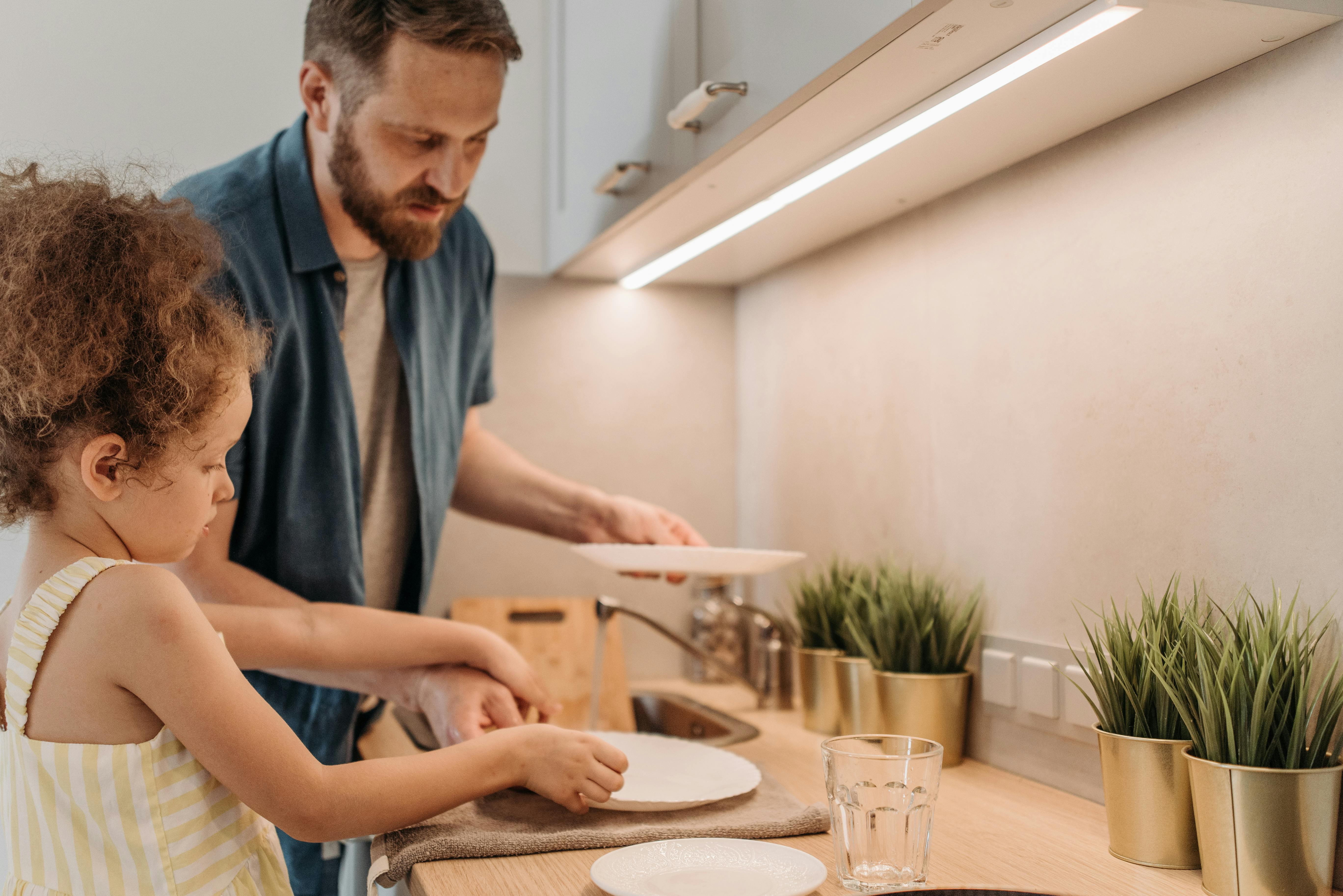 Un homme fait la vaisselle avec sa fille | Source : Pexels