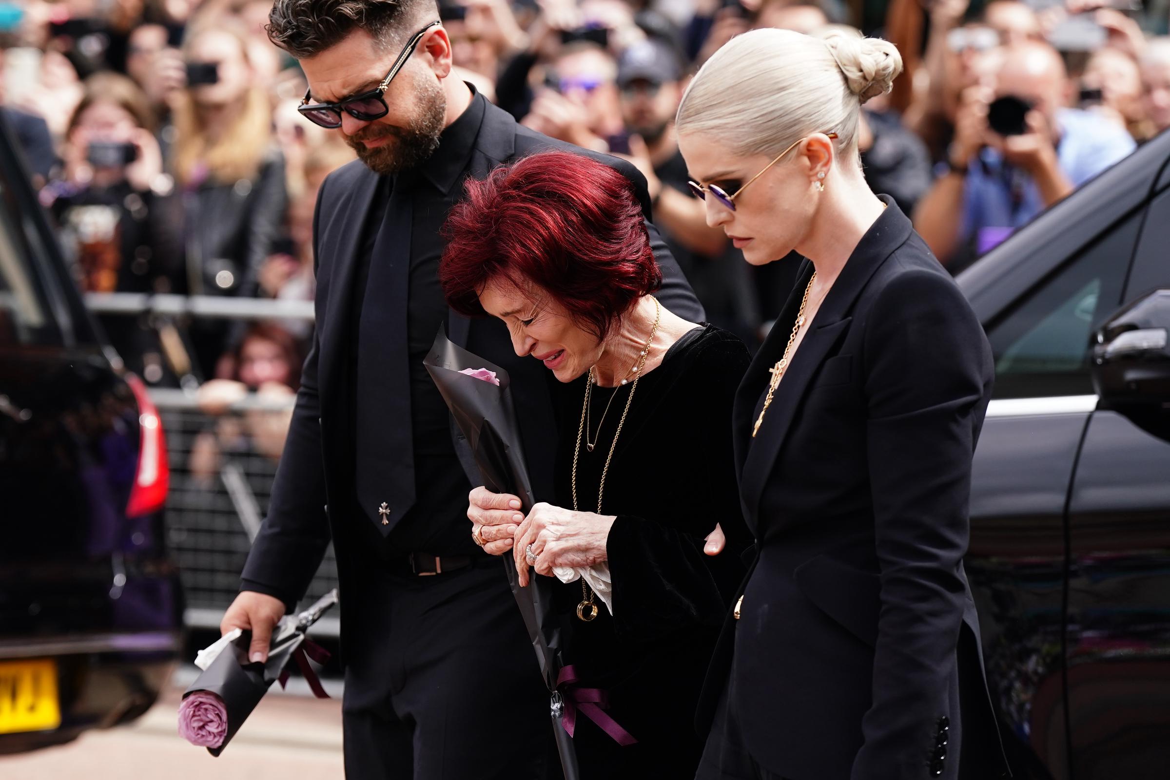 Sharon, Jack et Kelly déposant des fleurs sur le banc du pont Black Sabbath sur Broad Street à Birmingham le 30 juillet 2025 | Source : Getty Images