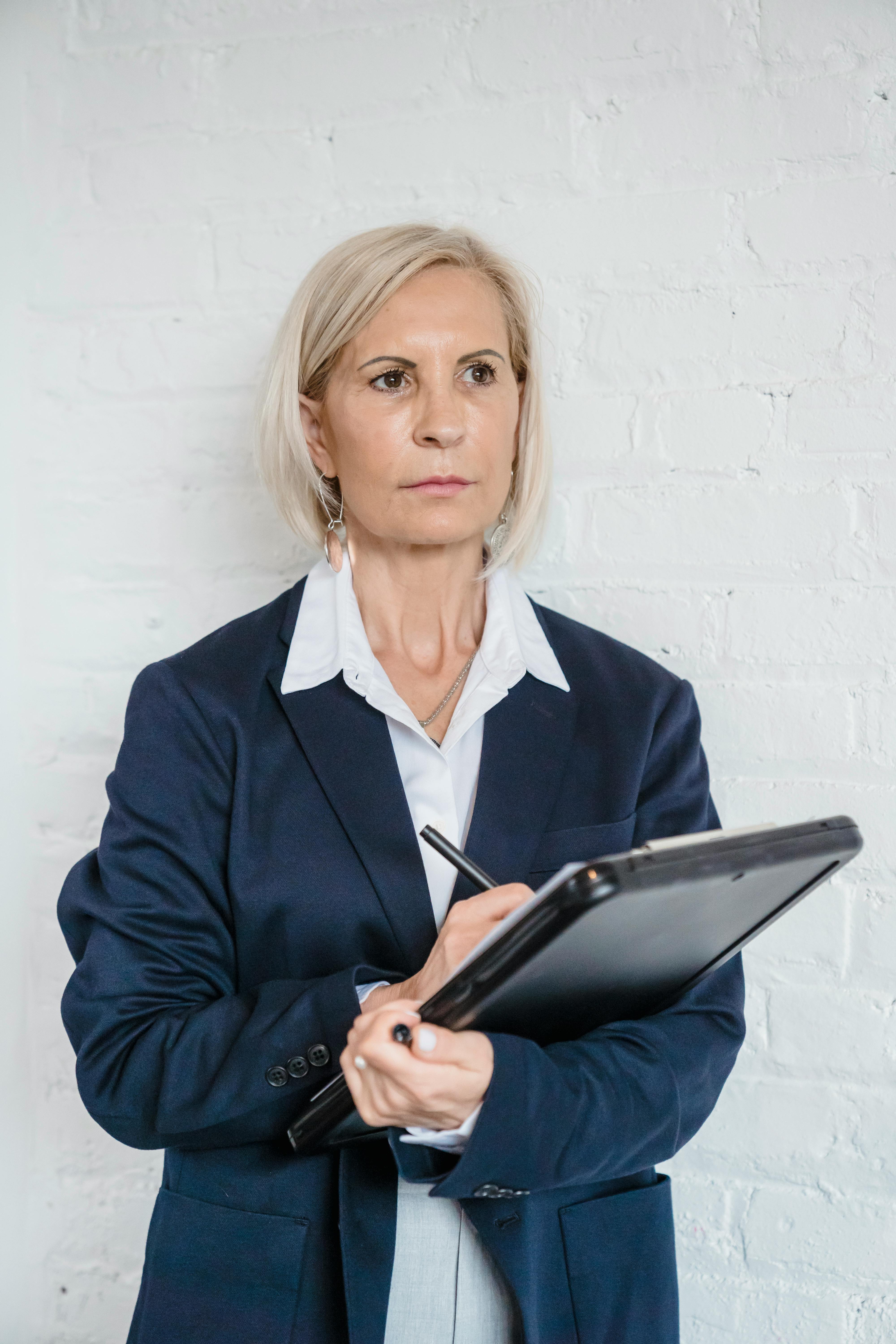 Une femme âgée tenant un bloc-notes | Source : Pexels