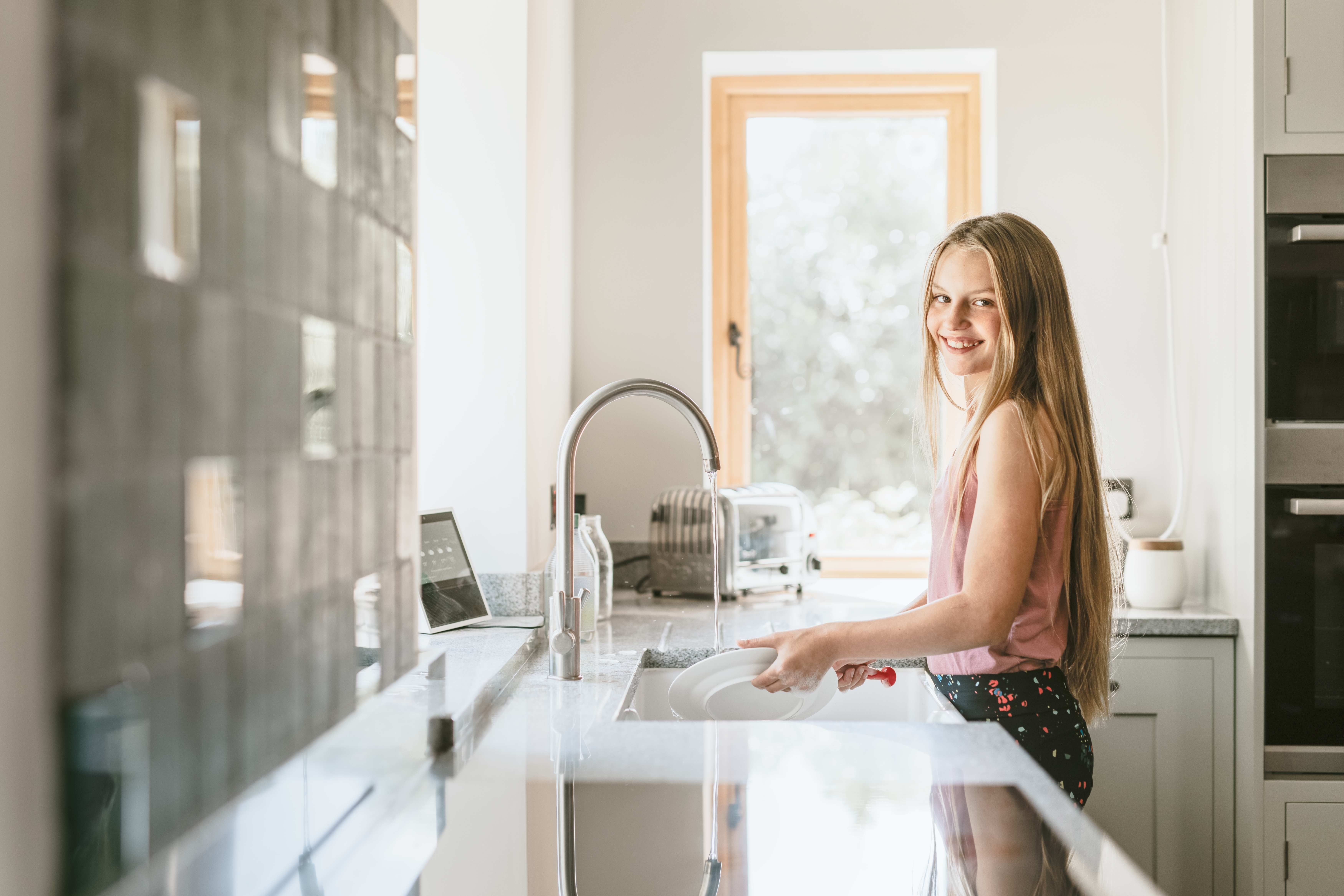 Une fille fait la vaisselle | Source : Shutterstock