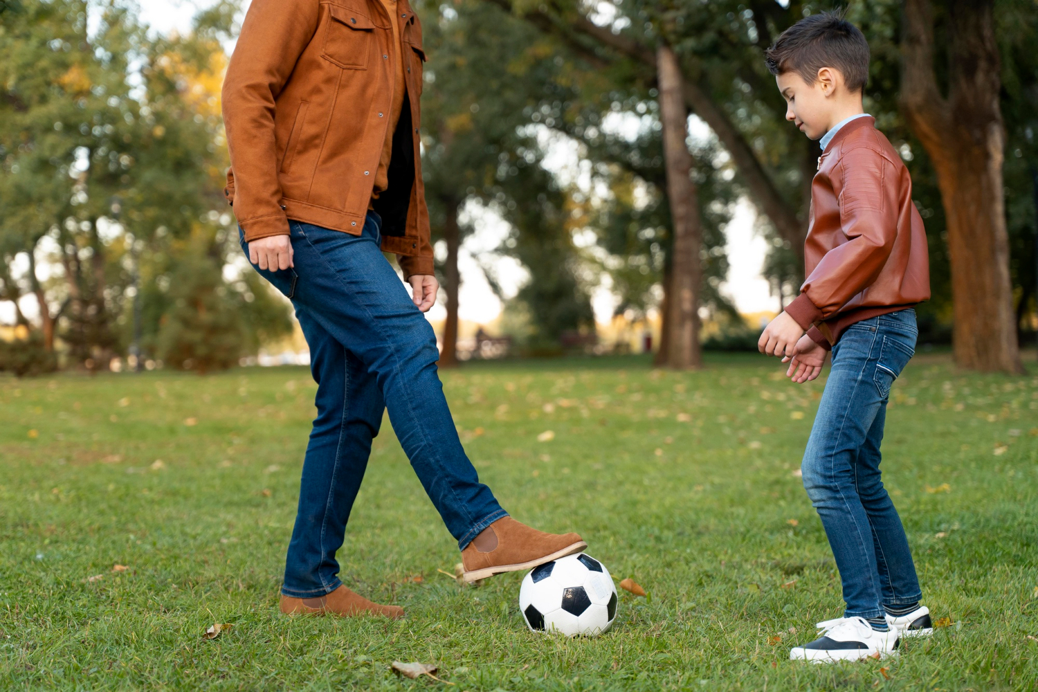 Un garçon qui joue au football avec son père | Source : Freepik