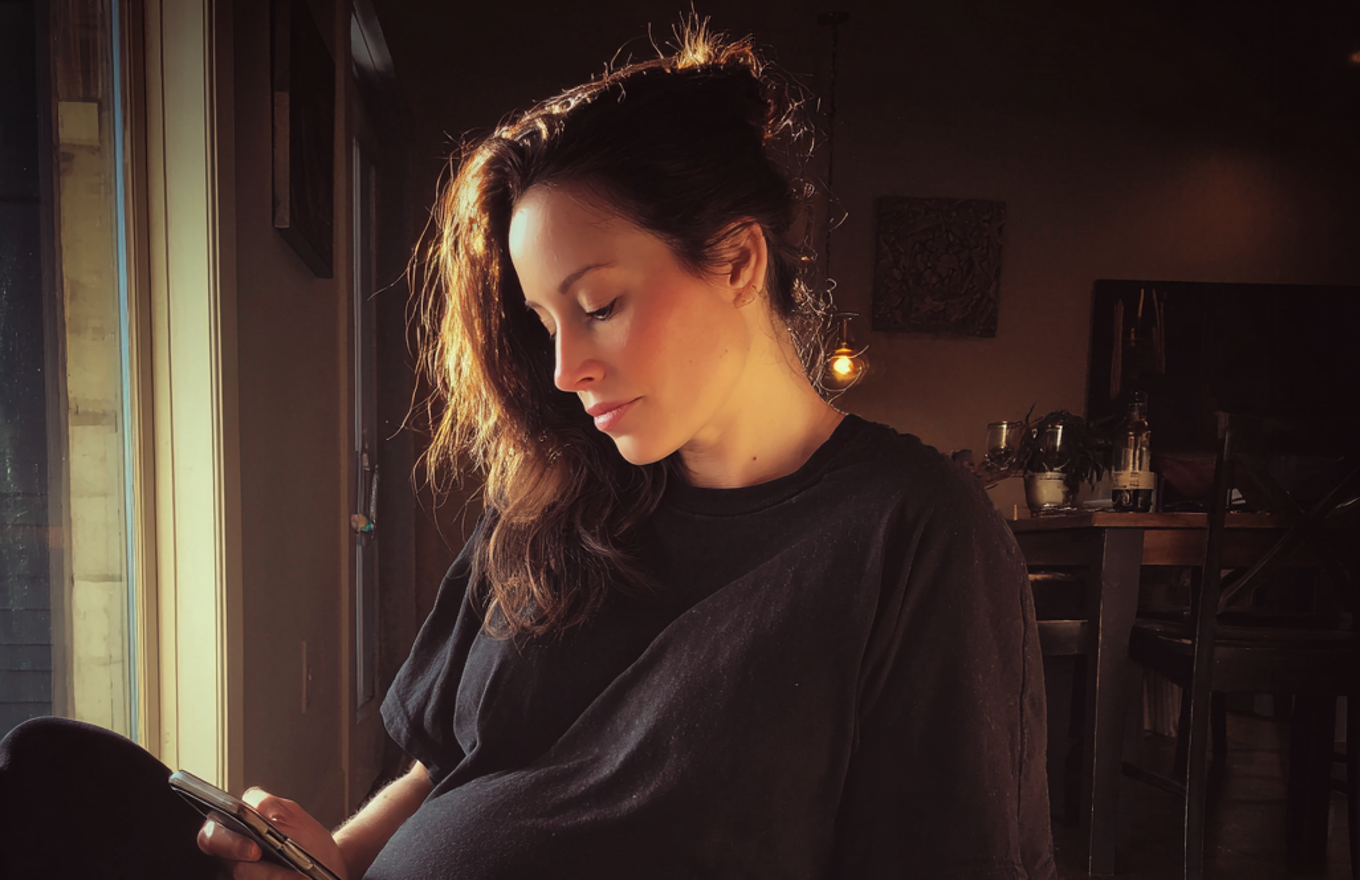 Une femme fatiguée qui utilise son téléphone | Source : Midjourney