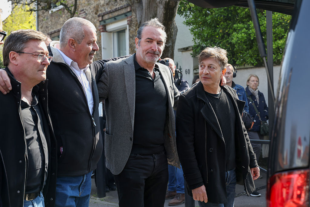 (de gauche à droite) Manu Joucla, Éric Collado, Jean Dujardin et Éric Massot marchent derrière le corbillard lors des funérailles de Bruno Salomone, le 23 mars 2026 à Joinville-le-Pont, en France I Source : Getty Images