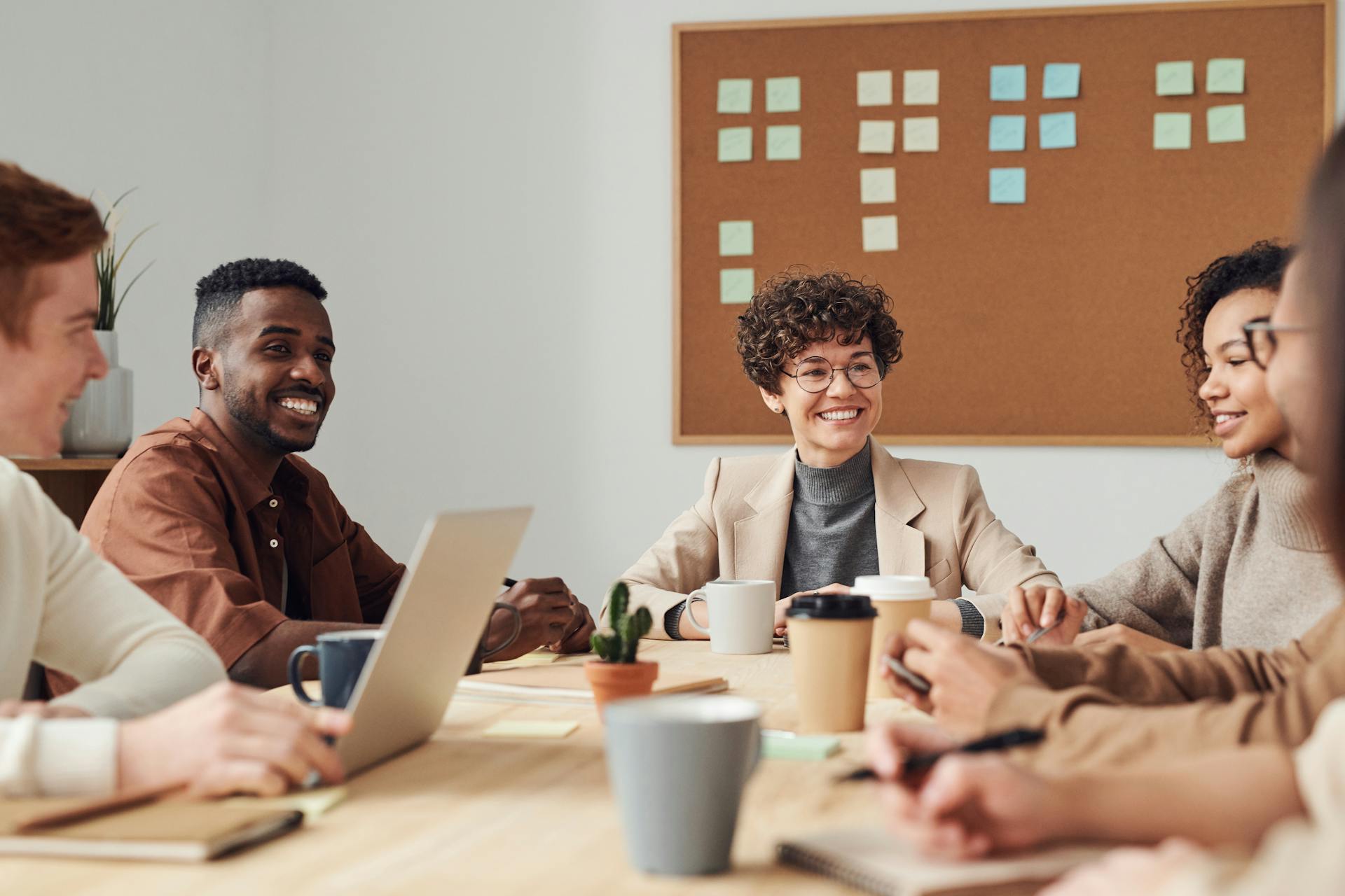 Une photo montrant des collègues de travail souriants travaillant ensemble | Source : Pexels