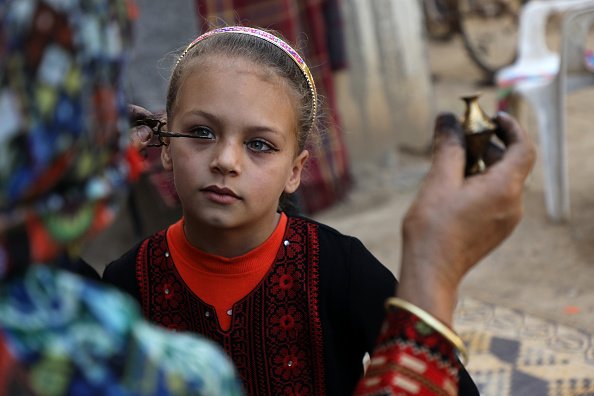 La Palestinienne Hadeya Qudaih, 60 ans, applique un eye-liner traditionnel au khôl à sa petite-fille à des fins médicales. |Photo : Getty Images