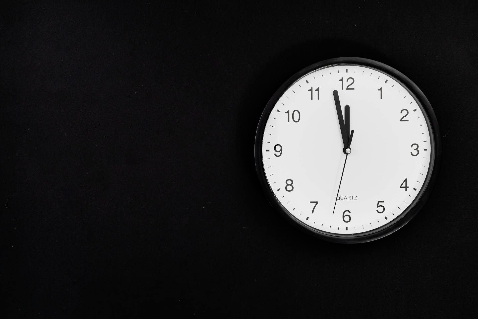 Une vieille horloge murale analogique indiquant 23h58. | Source : Pexels