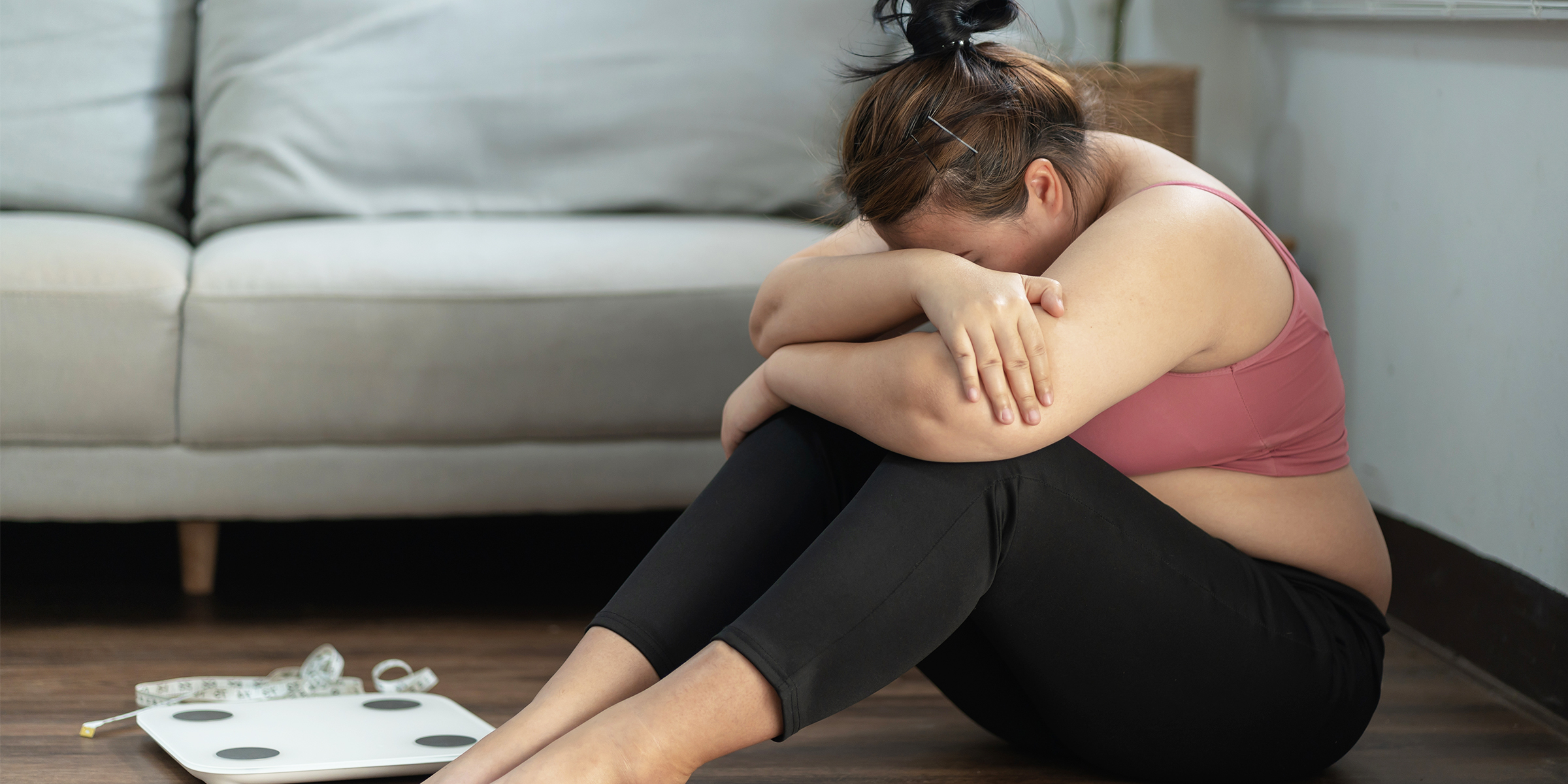 Une femme en pleurs assise à côté d'une balance | Source : Shutterstock