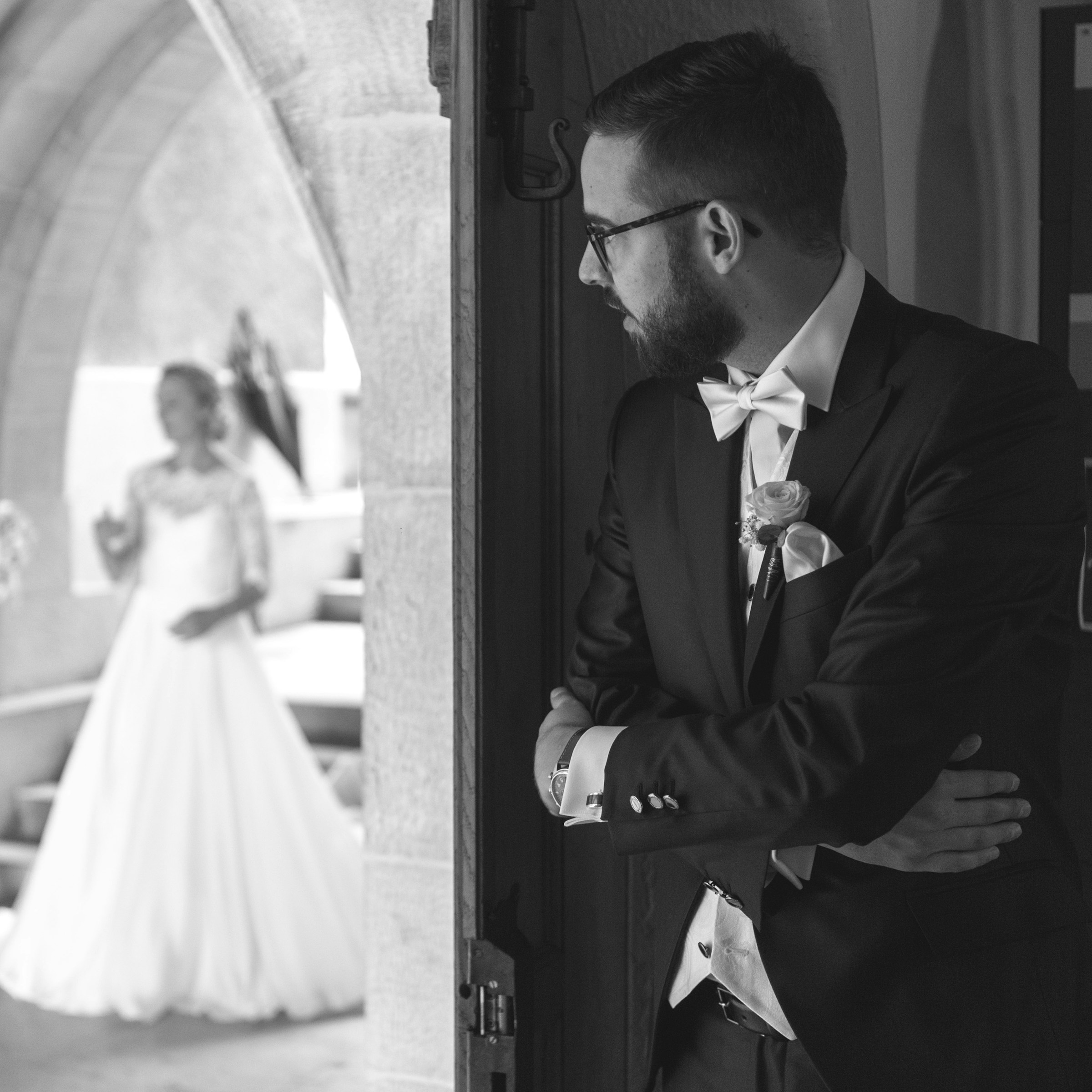 Un homme se tenant devant la porte d'une église et regardant la mariée | Source : Unsplash