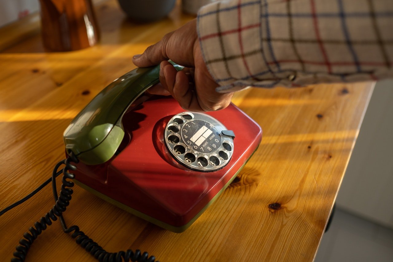 Un vieux téléphone posé sur une surface en bois | Source : Pexels