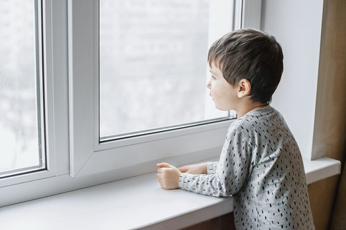 Un garçon malade au bord de la fenêtre | Photo : Shutterstock