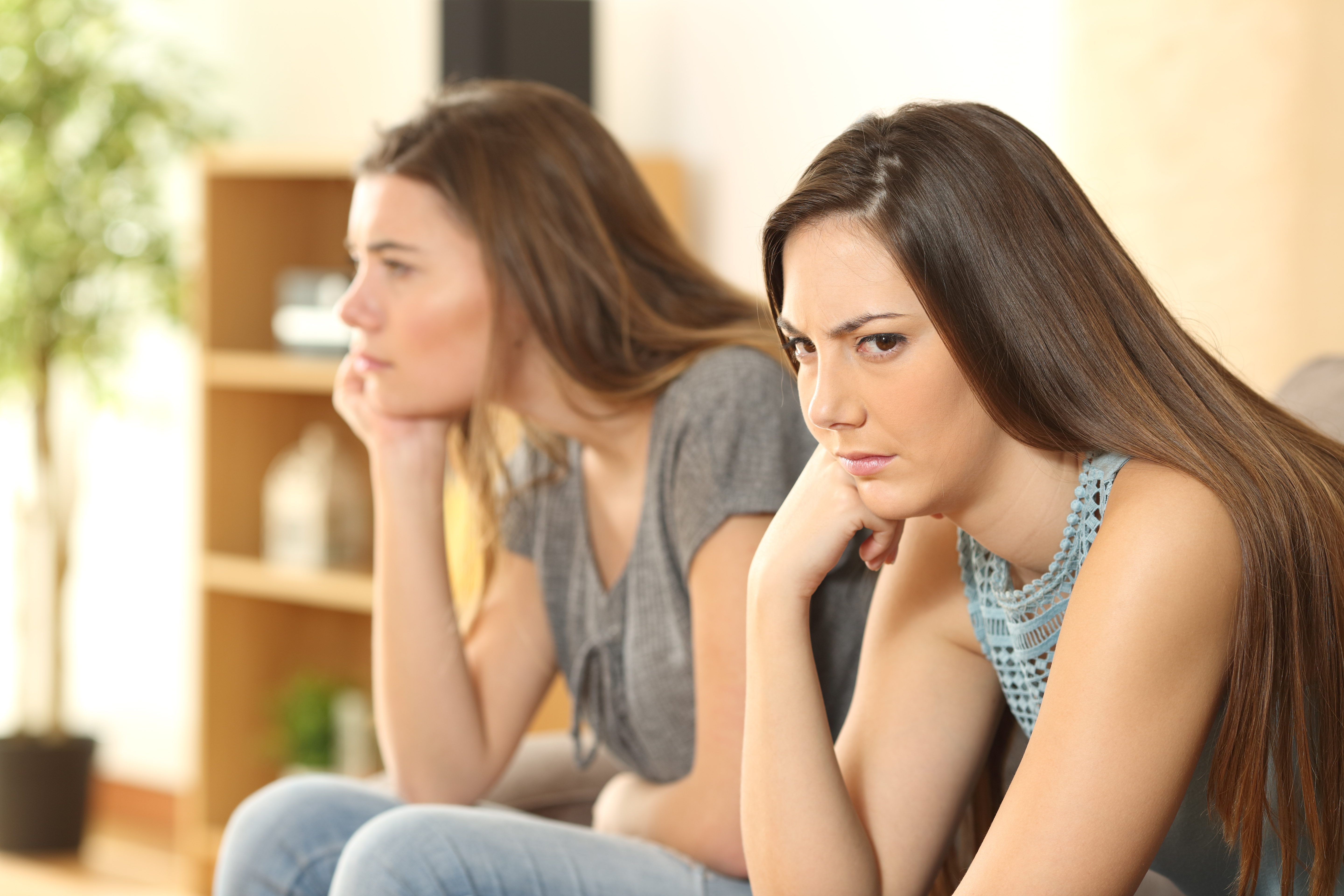 Deux sœurs assises sur un canapé, ne se parlant pas | Source : Shutterstock