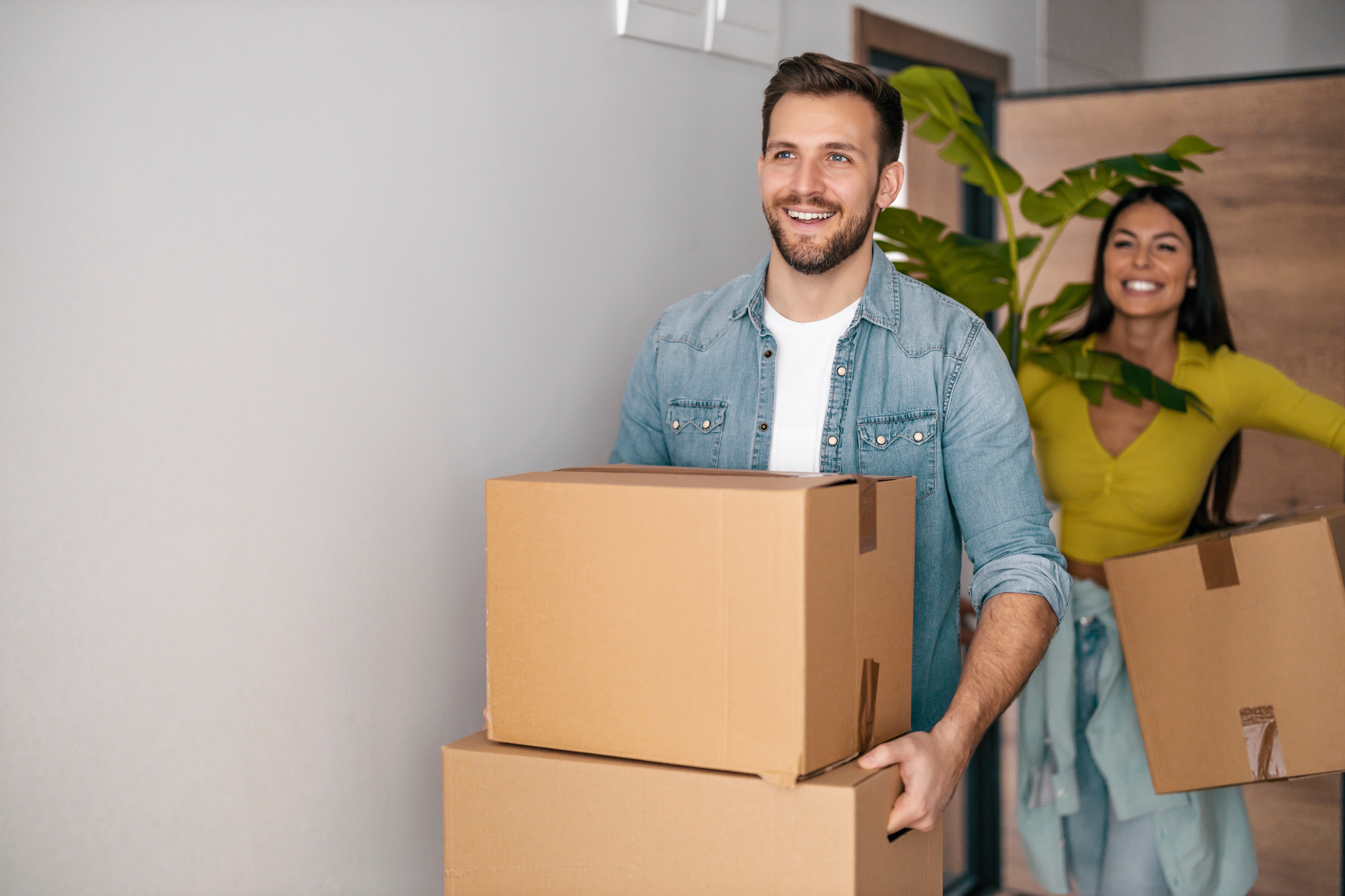Un jeune couple heureux avec des cartons dans leur nouvelle maison. | Source : Shutterstock