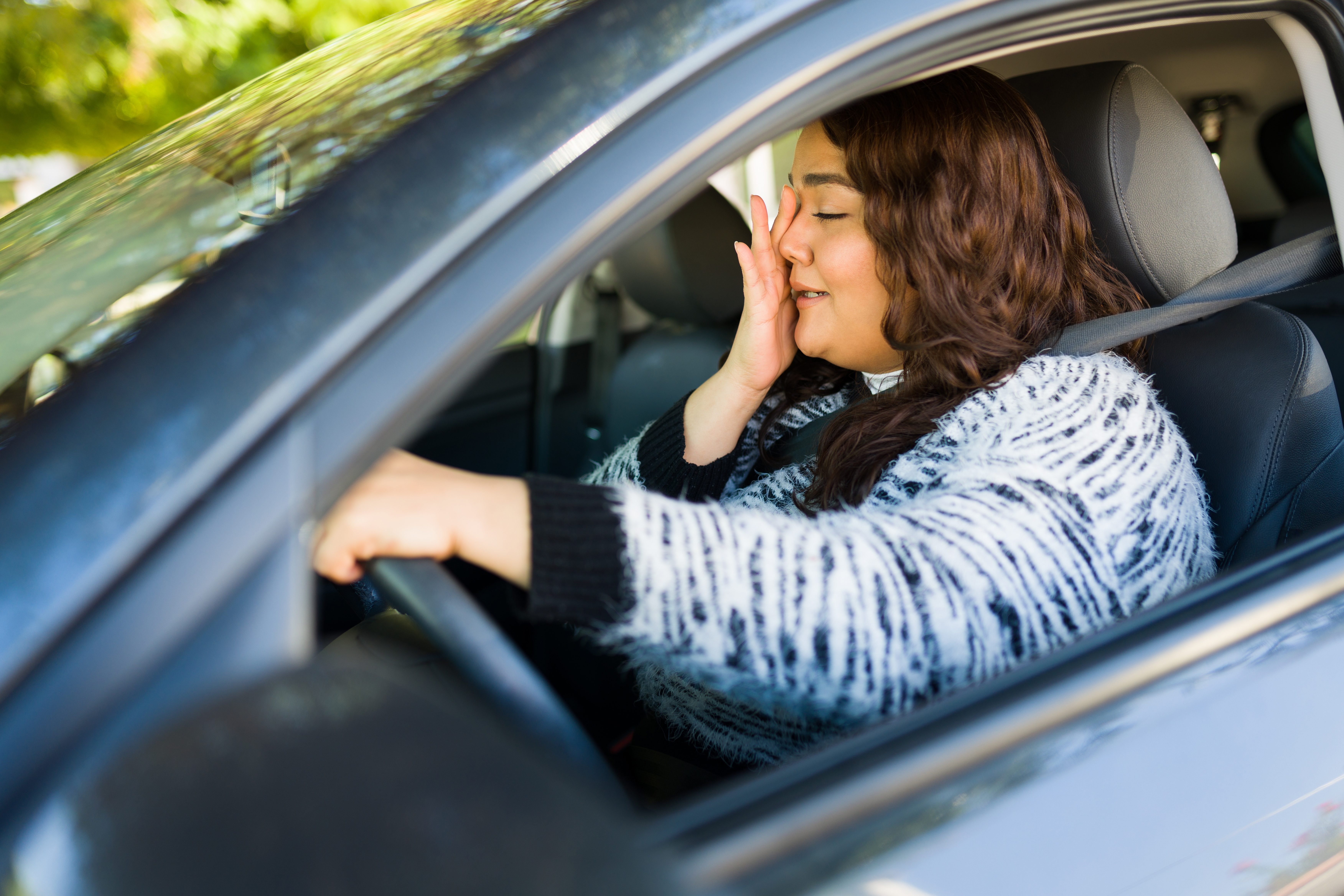 Une femme qui pleure en conduisant une voiture | Source : Shutterstock