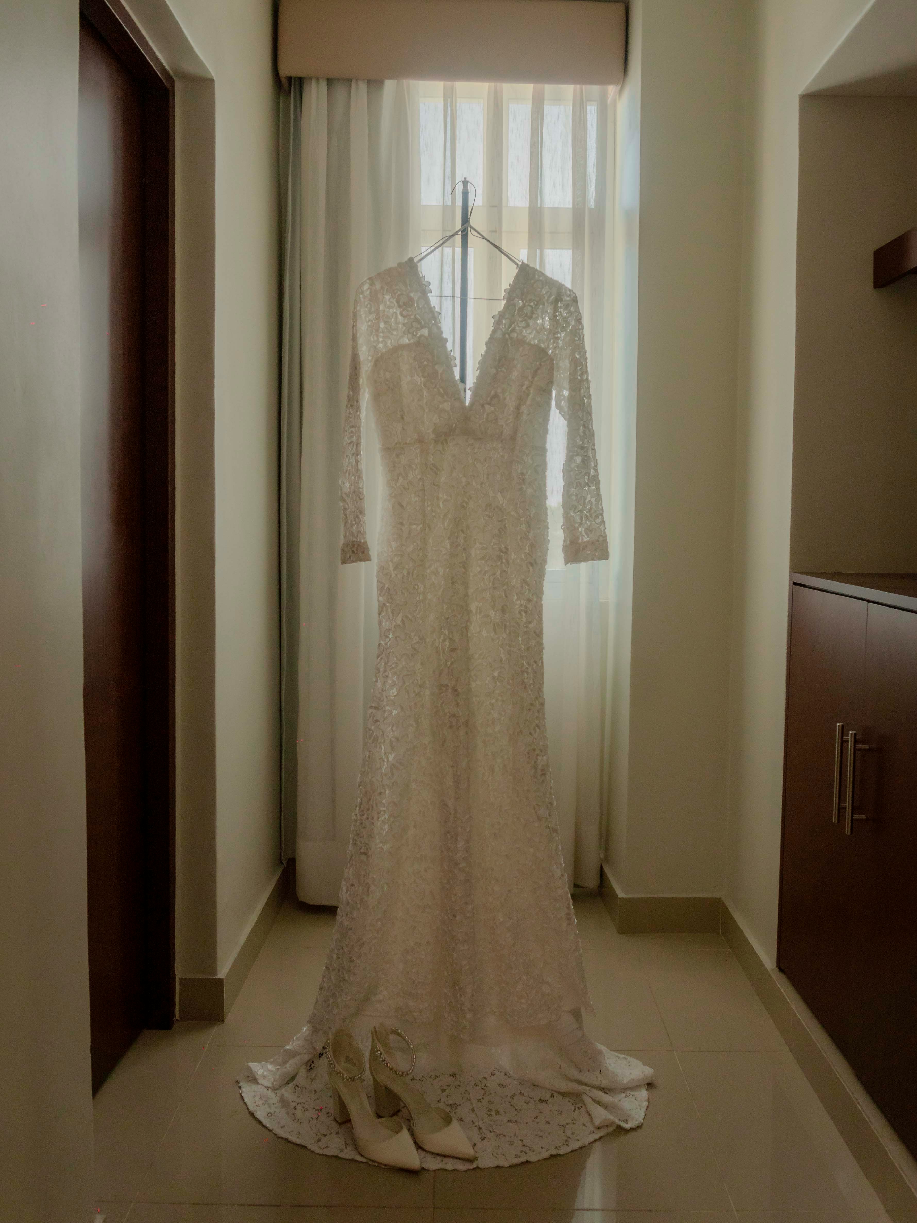 Une robe de mariée suspendue devant une fenêtre | Source : Unsplash