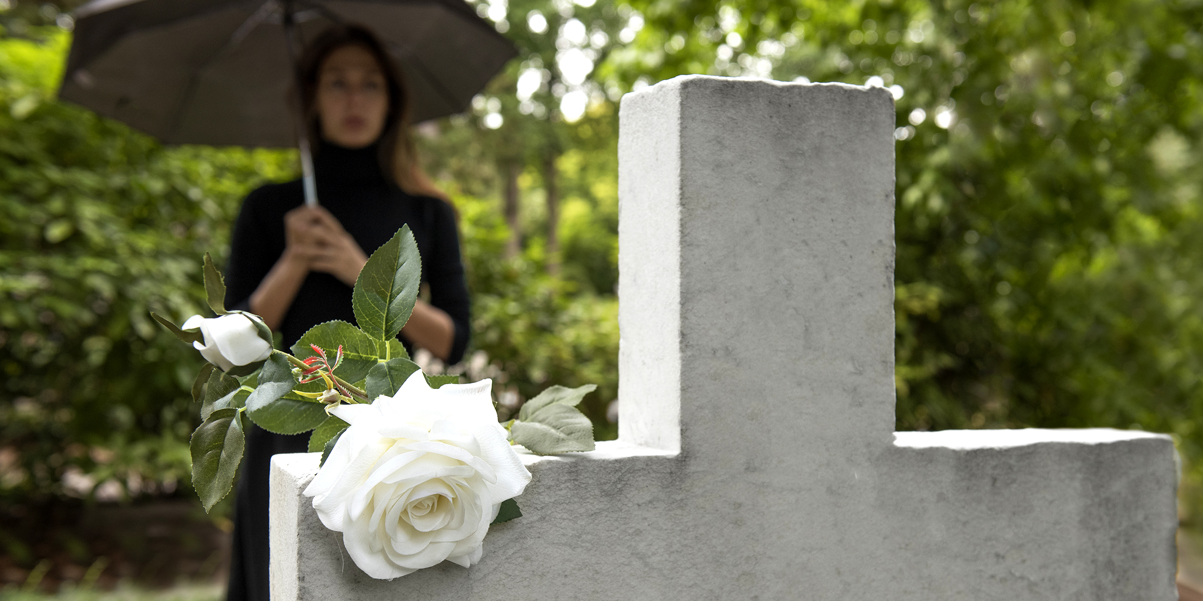 Une femme debout près d'une tombe | Source : freepik.com/freepik