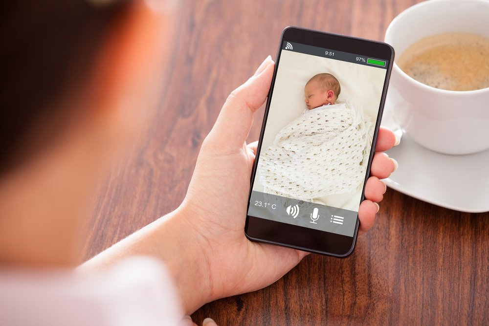 Une mère surveille son bébé via Video Babyphone. | Shutterstock