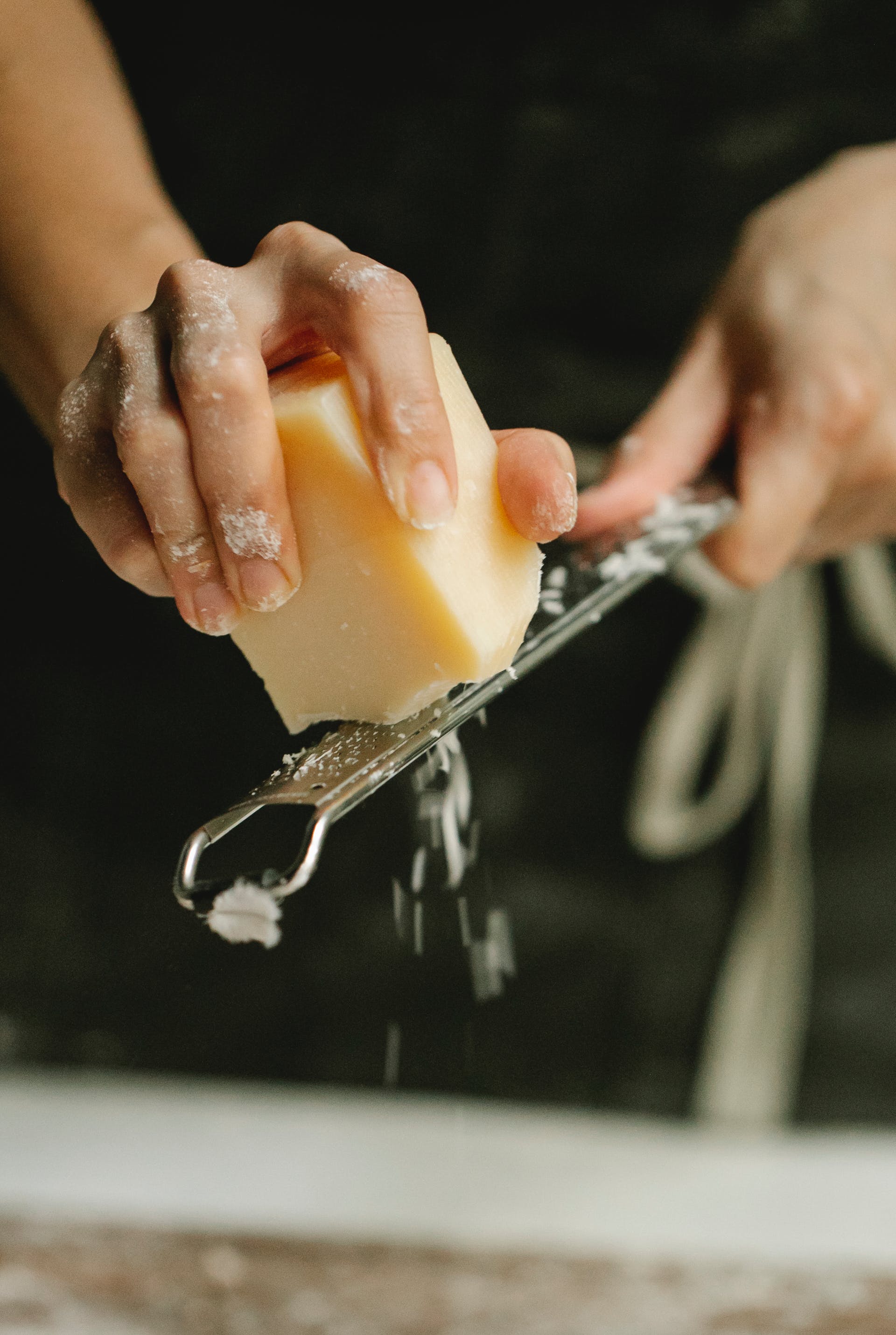 Uma pessoa ralando queijo | Fonte: Pexels