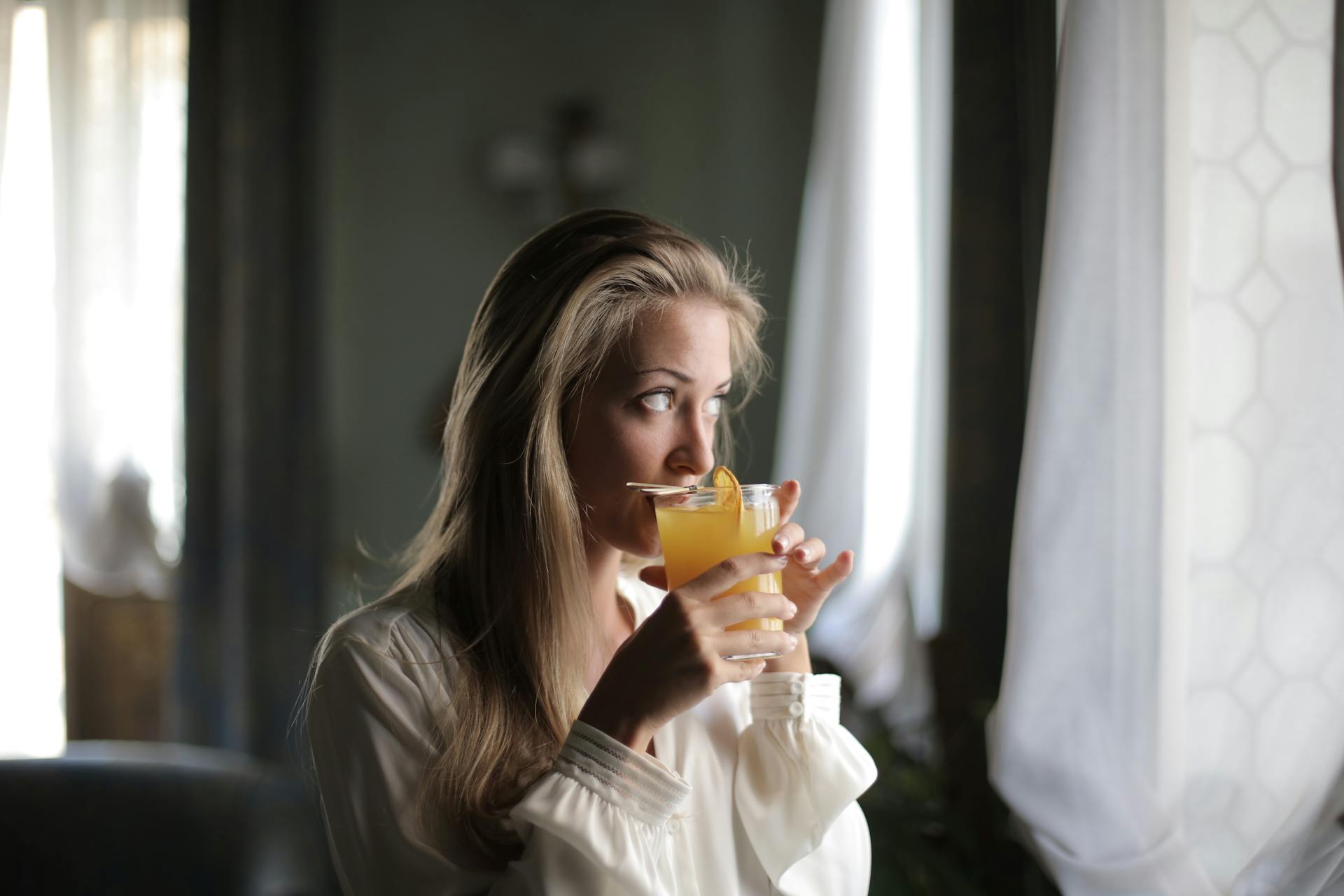 Une femme qui boit du jus d'orange | Source : Pexels
