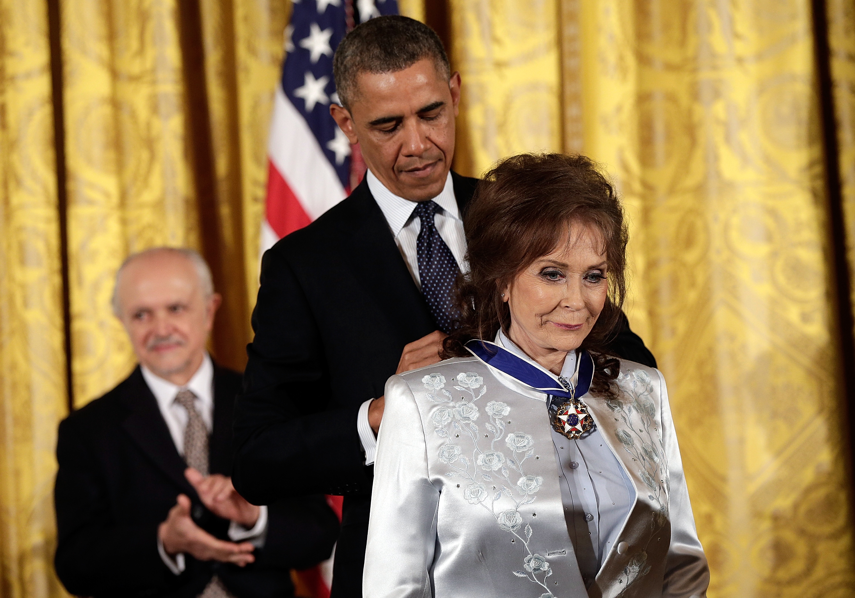Barack Obama remet la médaille présidentielle de la liberté à Loretta Lynn dans la salle Est de la Maison Blanche à Washington, DC, le 20 novembre 2013. | Source : Getty Images