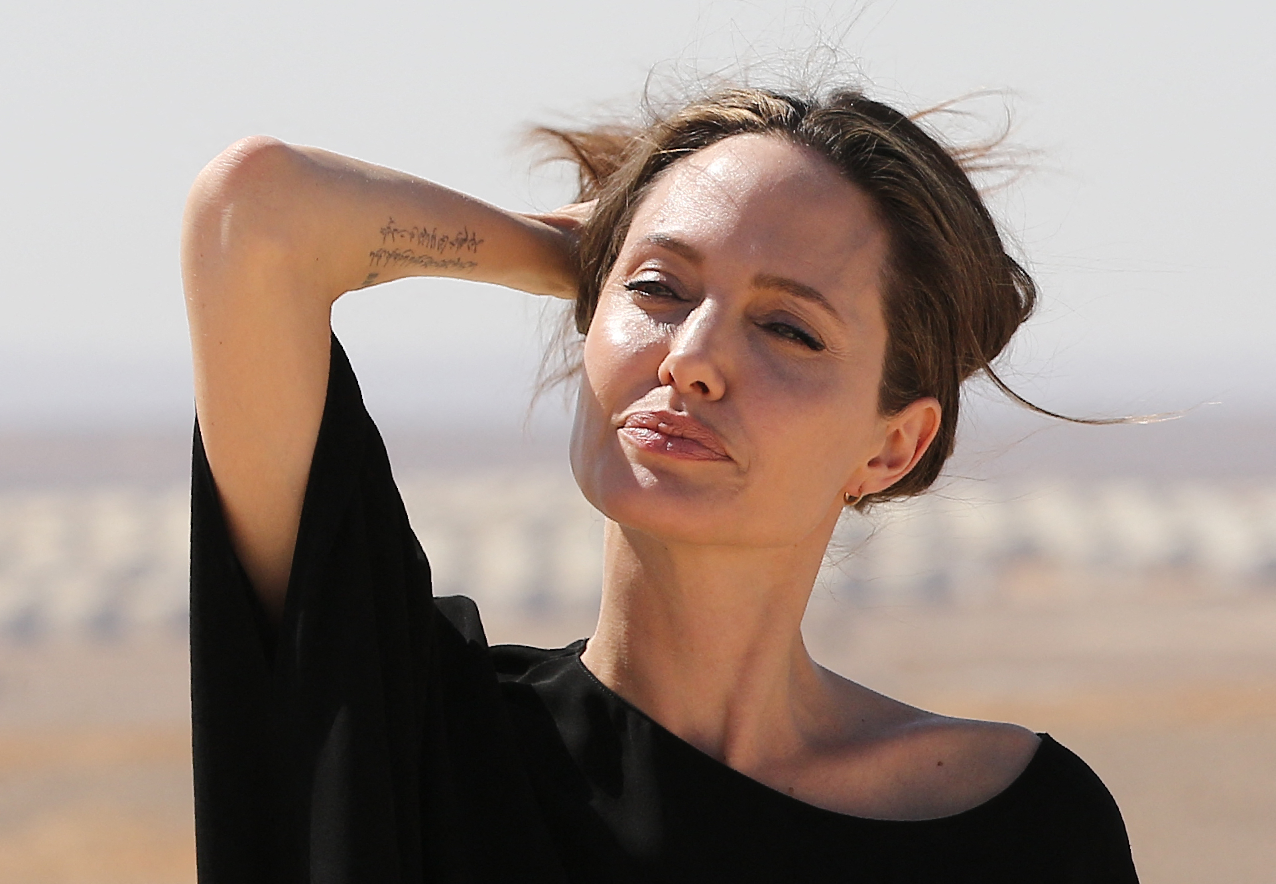 Angelina Jolie fait un geste lors d'une visite dans un camp de réfugiés syriens à Azraq, dans le nord de la Jordanie, le 9 septembre 2016 | Source : Getty Images