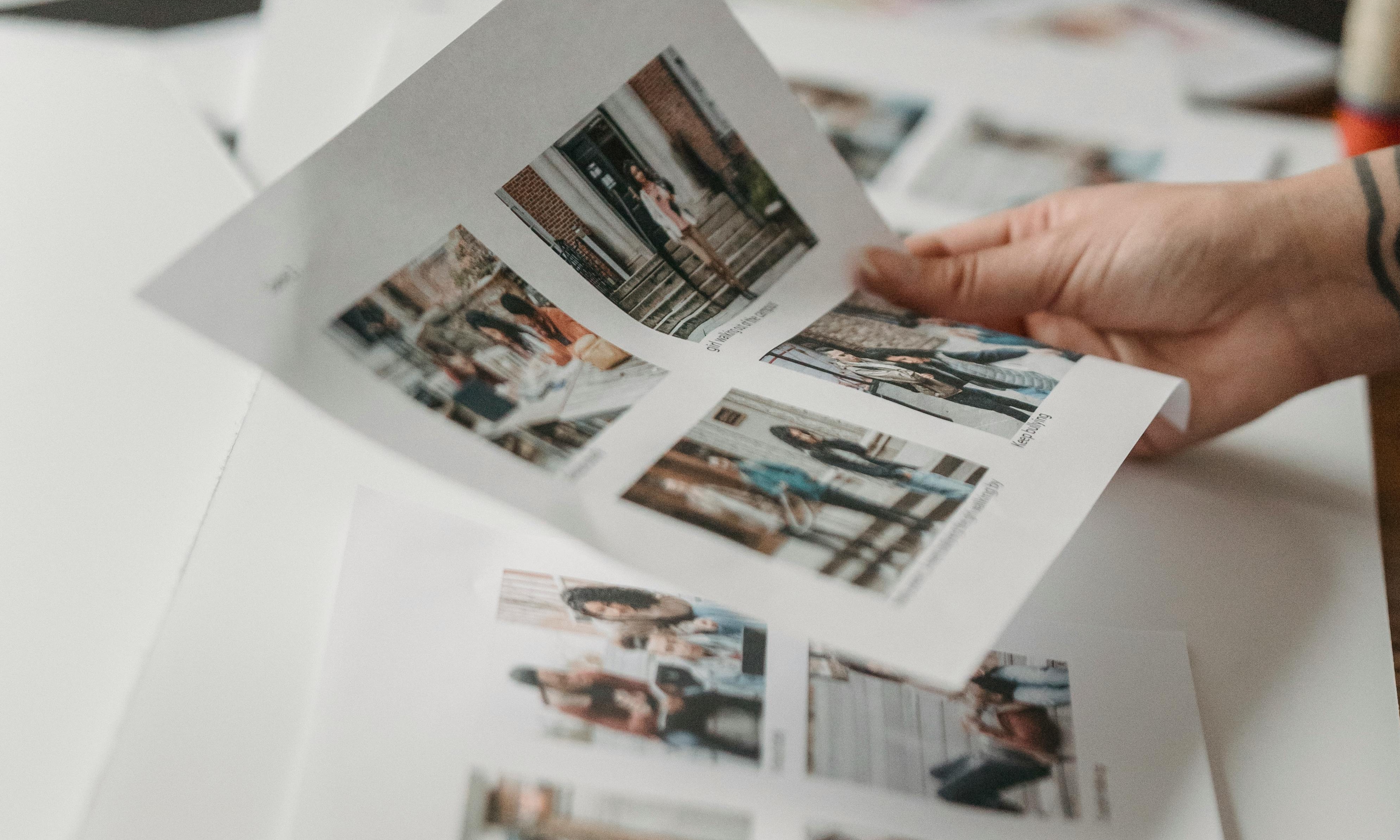 Une main tenant une page de photos imprimées | Source : Pexels