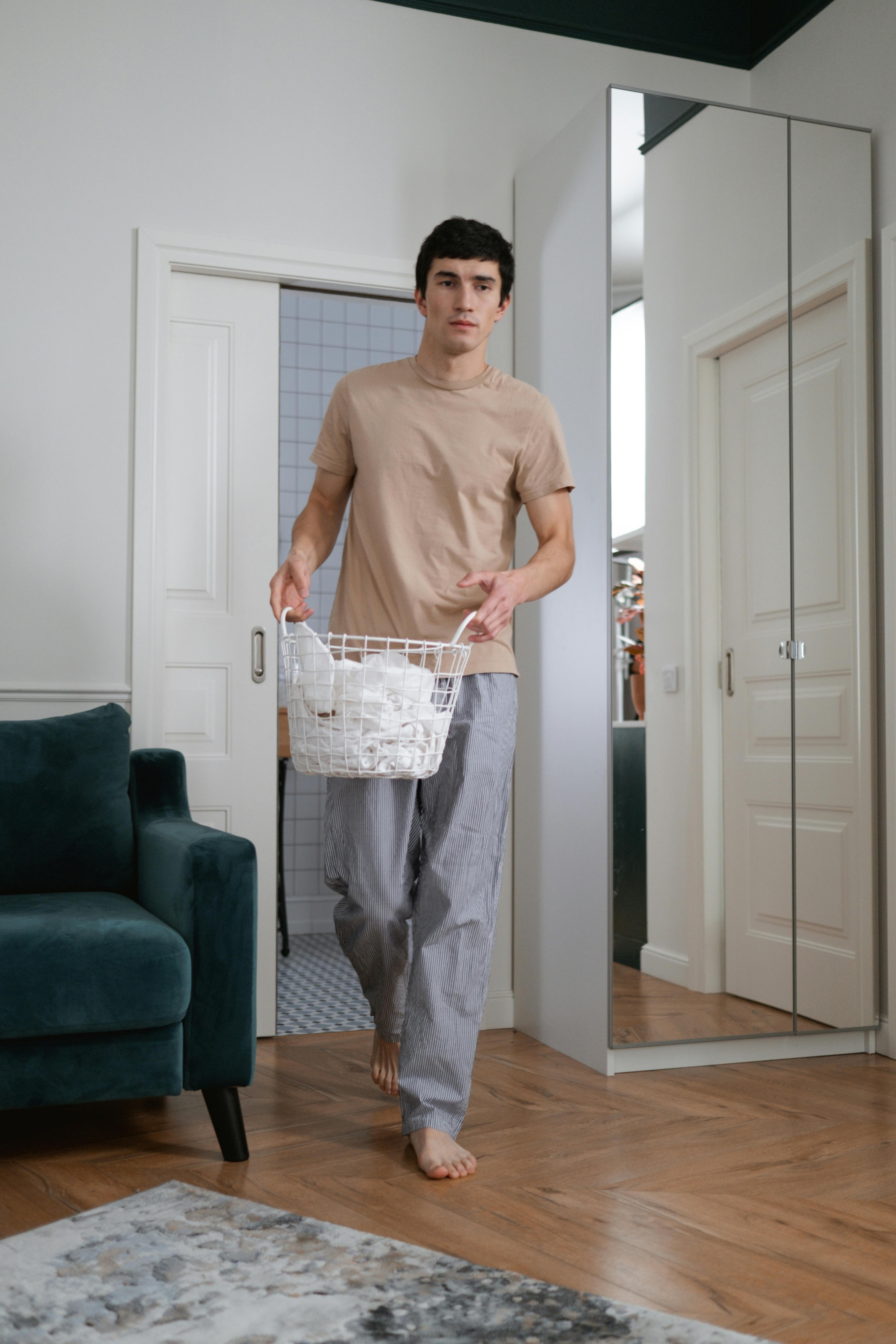 Un homme tenant un panier à linge avec des vêtements | Source : Pexels