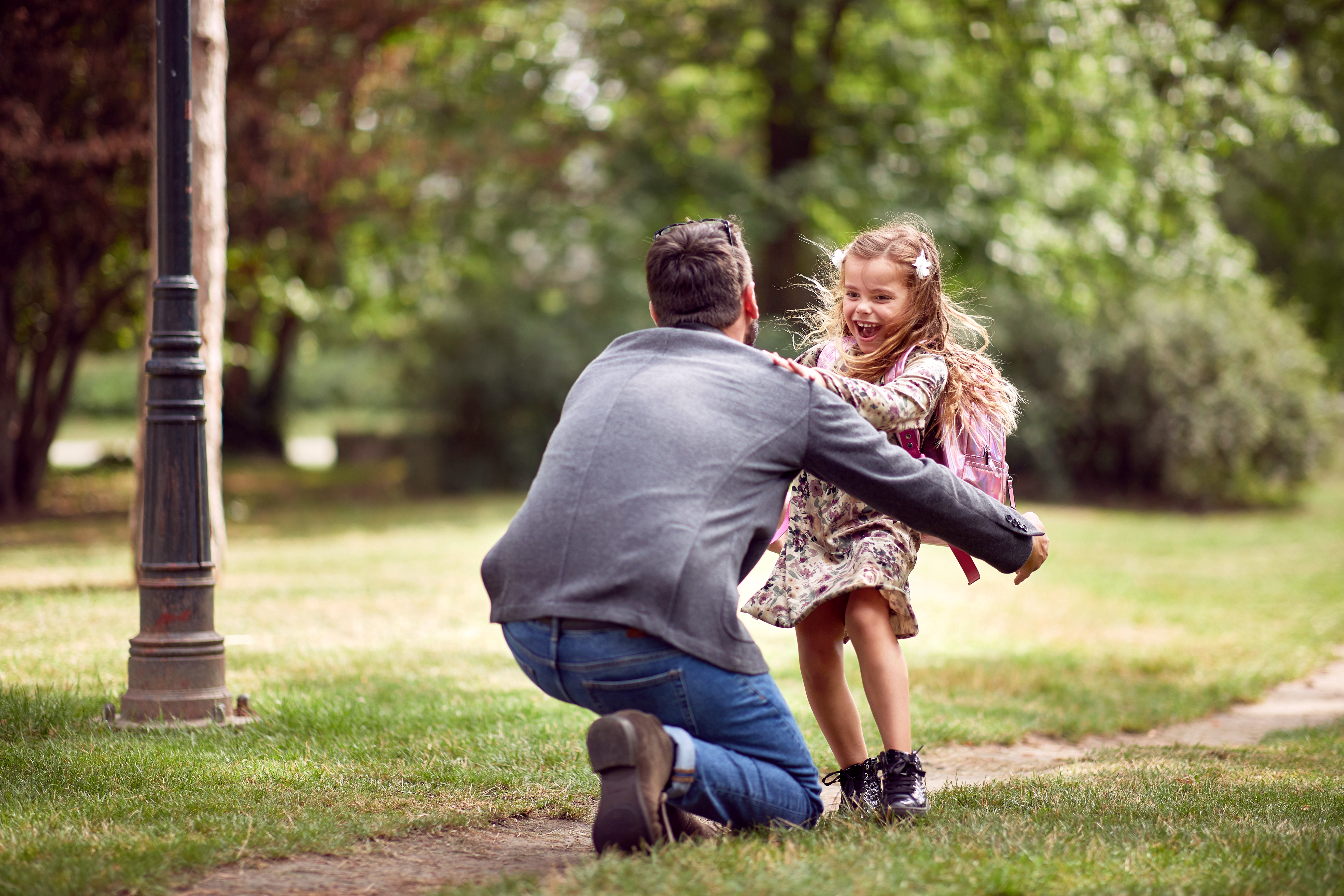 Homme jouant avec une petite fille dans un parc | Source : Shutterstock