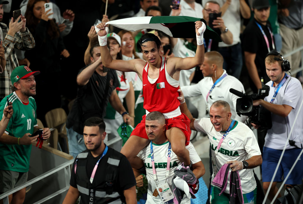 Imane Khelif, de l'équipe d'Algérie, célèbre sa médaille d'or avec les entraîneurs de l'équipe d'Algérie, Mohamed Chaoua et Mohamed Al-Shawa, après la finale de boxe féminine des 66 kg contre Liu Yang, de l'équipe de Chine, le quatorzième jour des Jeux Olympiques de Paris 2024 à Roland Garros, le 9 août 2024 à Paris, en France.