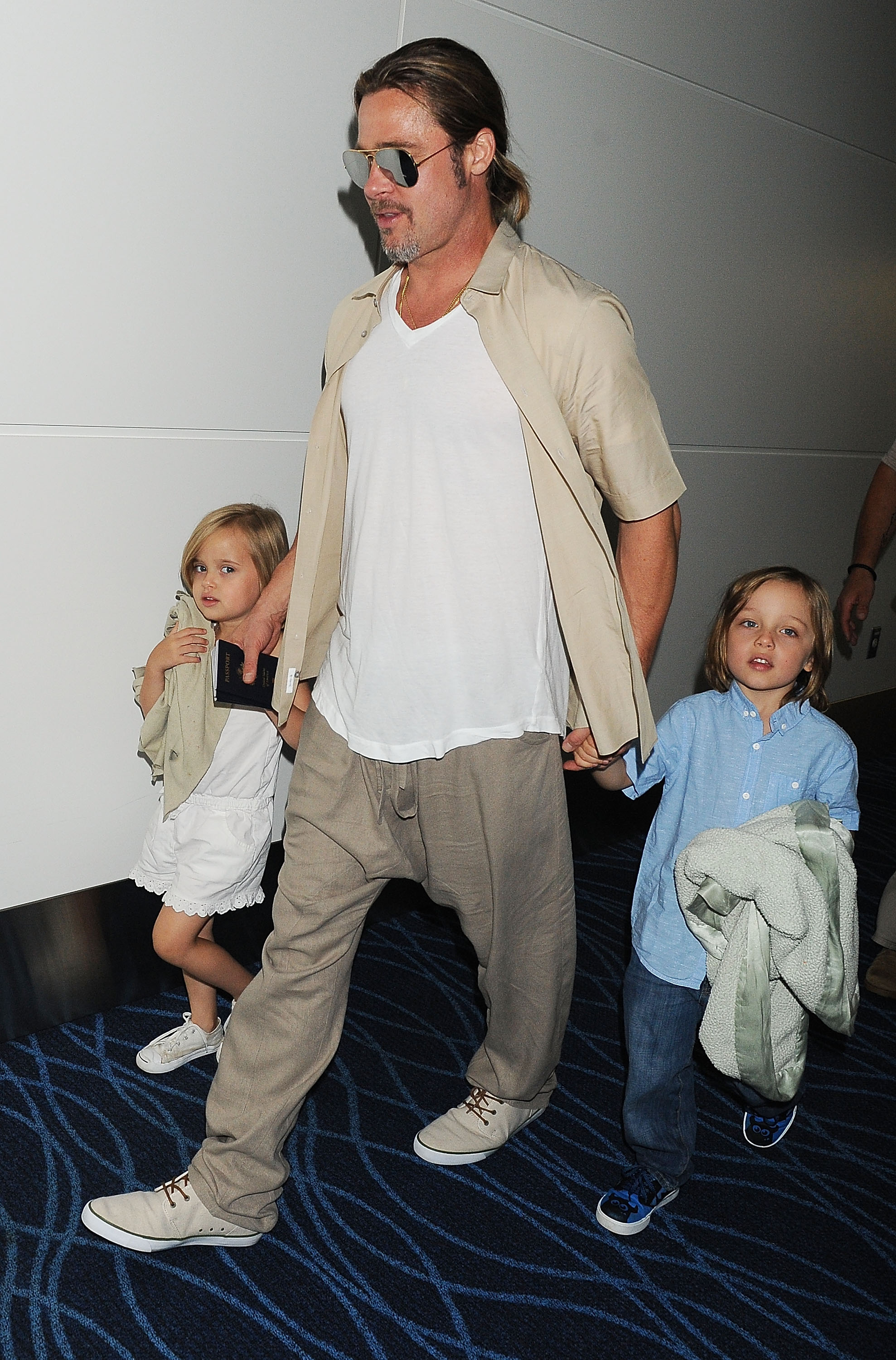 Brad Pitt et ses enfants jumeaux Knox et Vivienne Jolie-Pitt, le 30 juillet 2013, à Tokyo, au Japon | Source : Getty Images