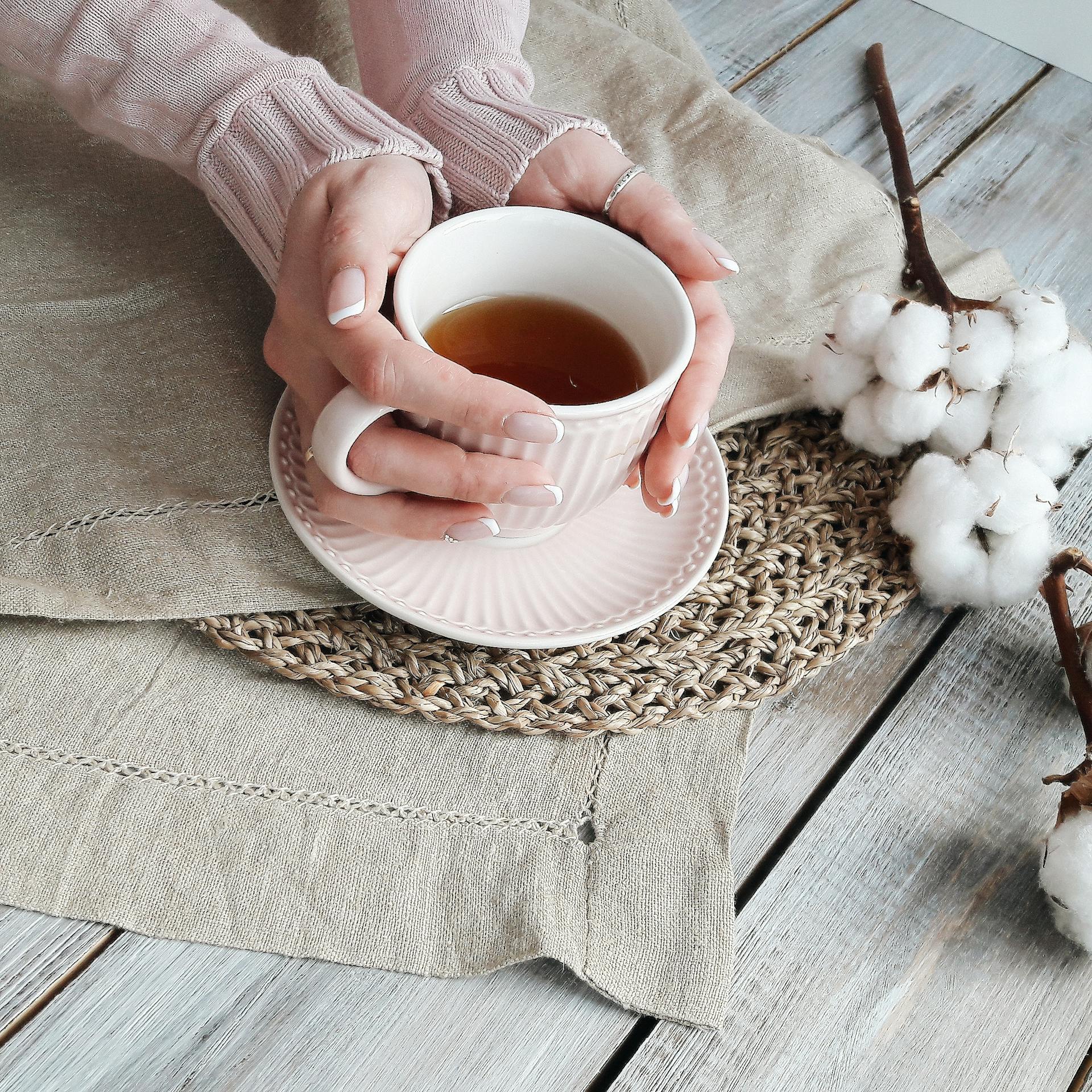 Les mains d'une femme enroulées autour d'une tasse de thé | Source : Pexels