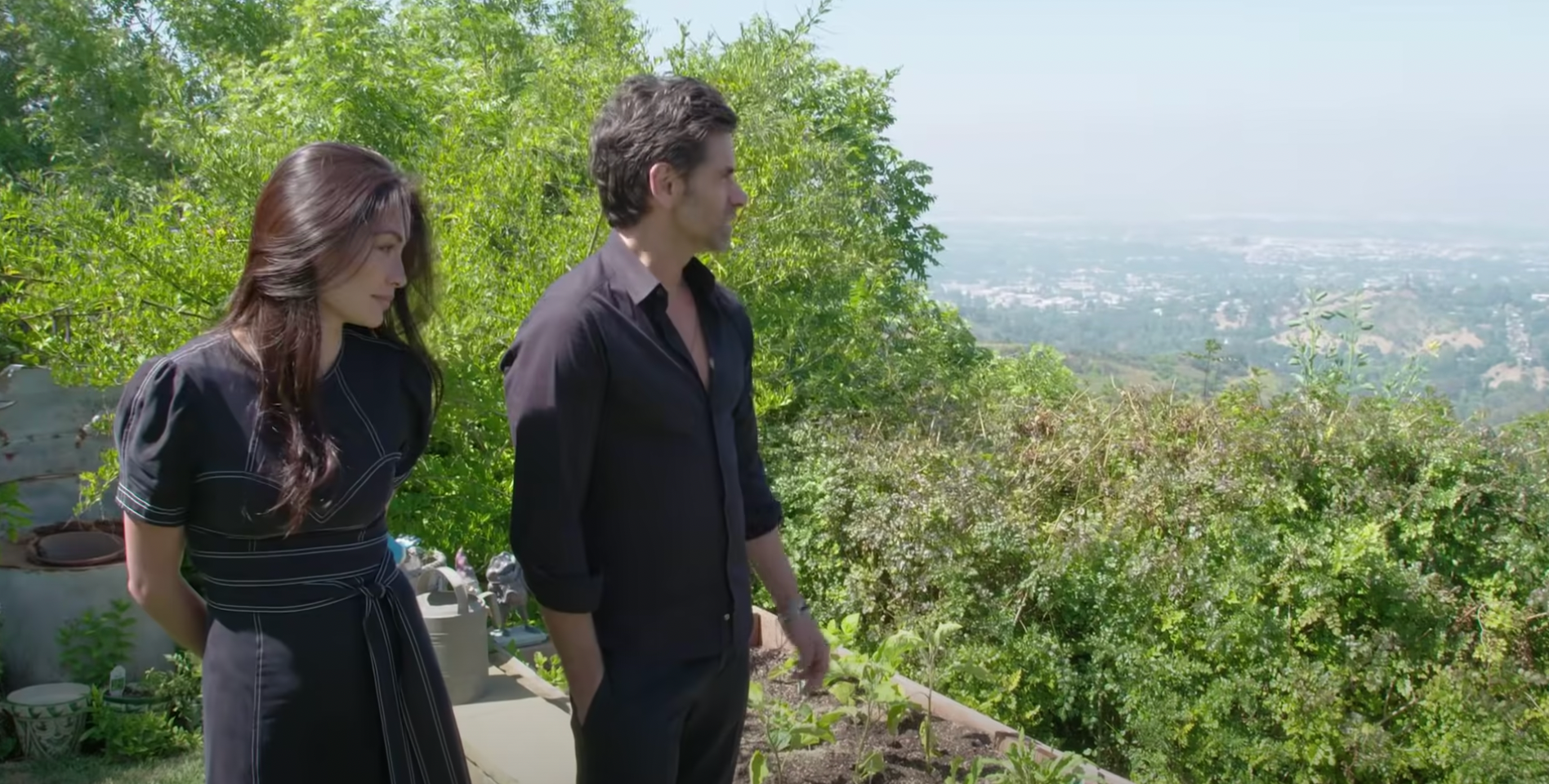 John Stamos et Caitlin McHugh photographiés en train de regarder la vue depuis leur jardin dans leur ancienne maison de Los Angeles | Source : YouTube@ArchitecturalDigest
