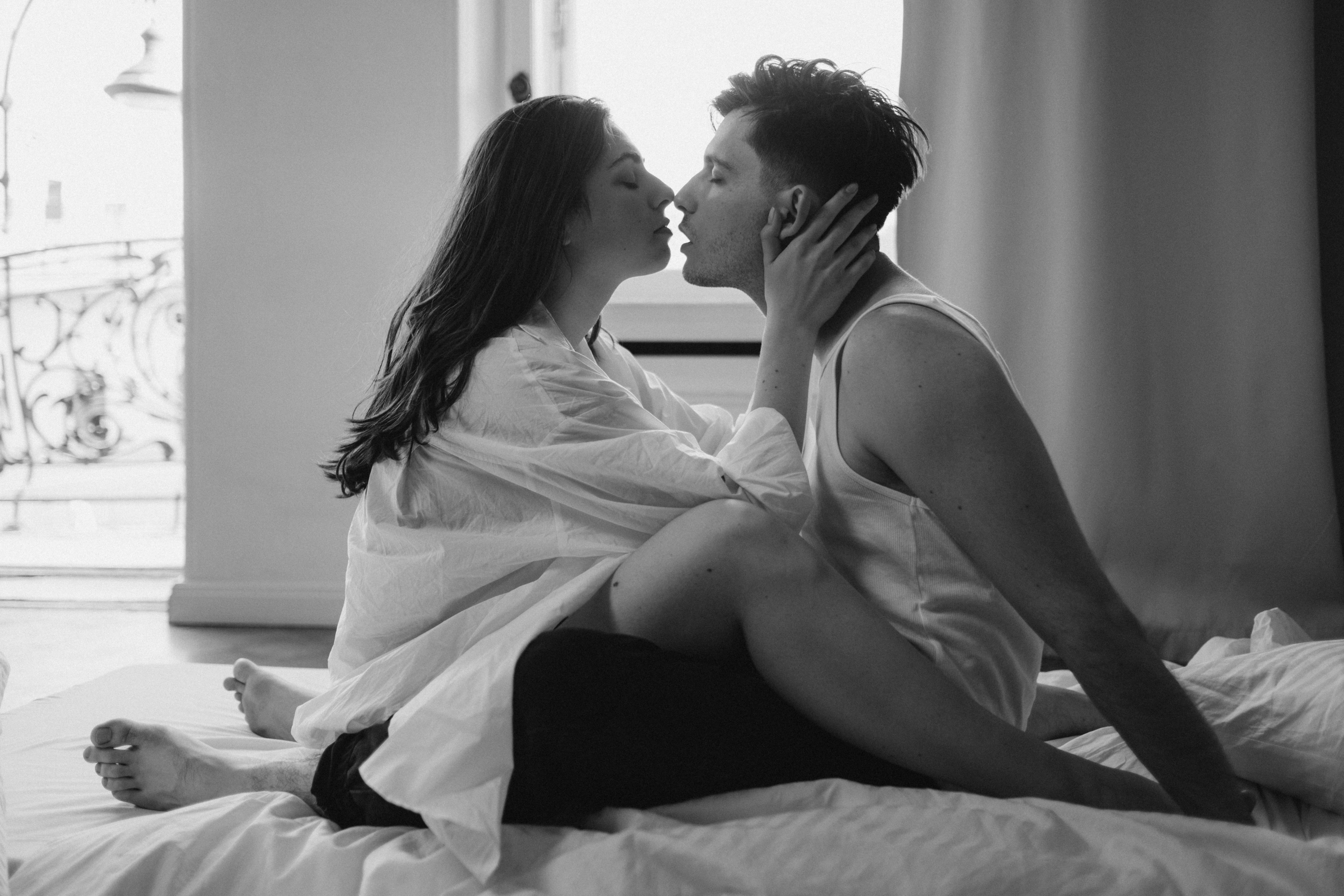 Un couple enlacé sur le point de partager un baiser au lit | Source : Pexels