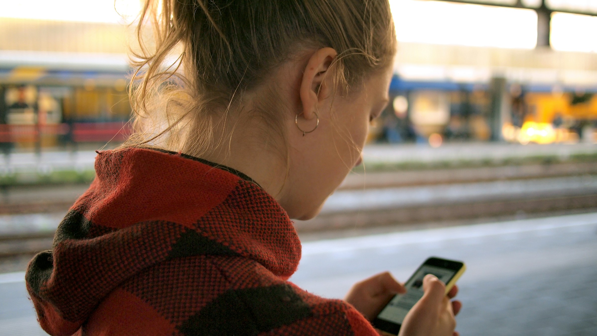 Une jeune femme qui regarde son smartphone | Source : Unsplash