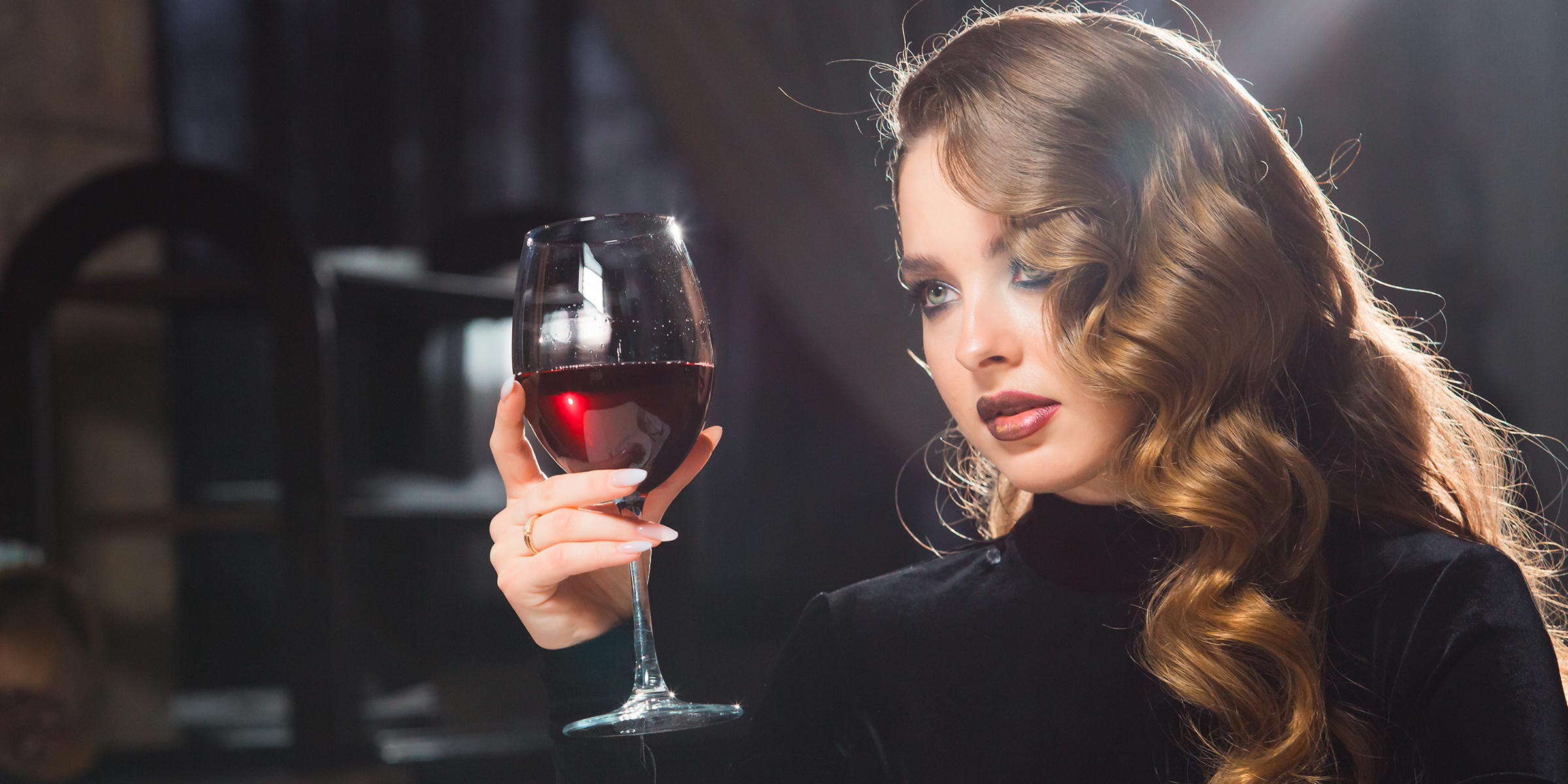 Une femme tenant un verre de vin | Source : Shutterstock