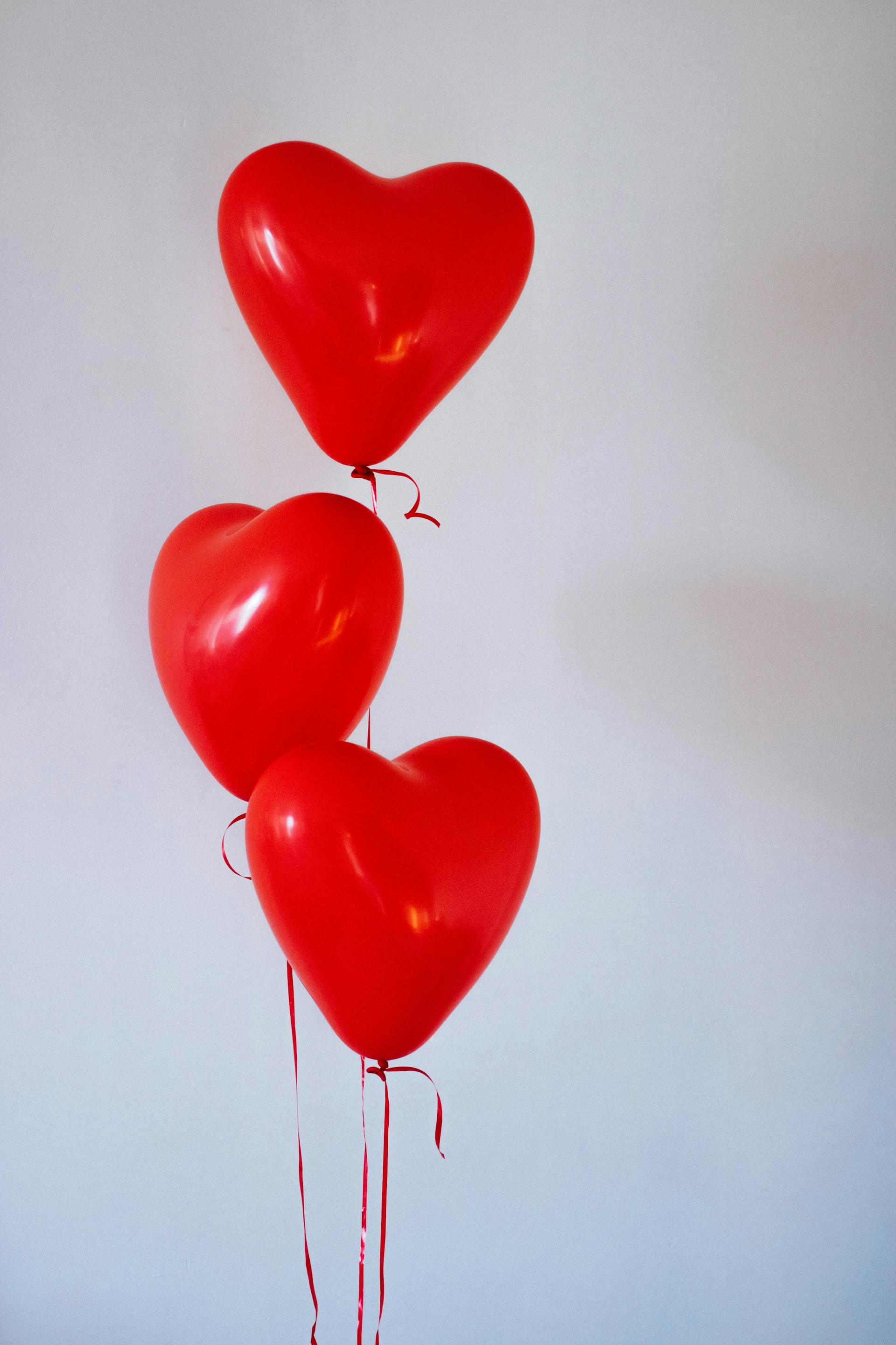 Trois ballons rouges en forme de cœur | Source : Pexels