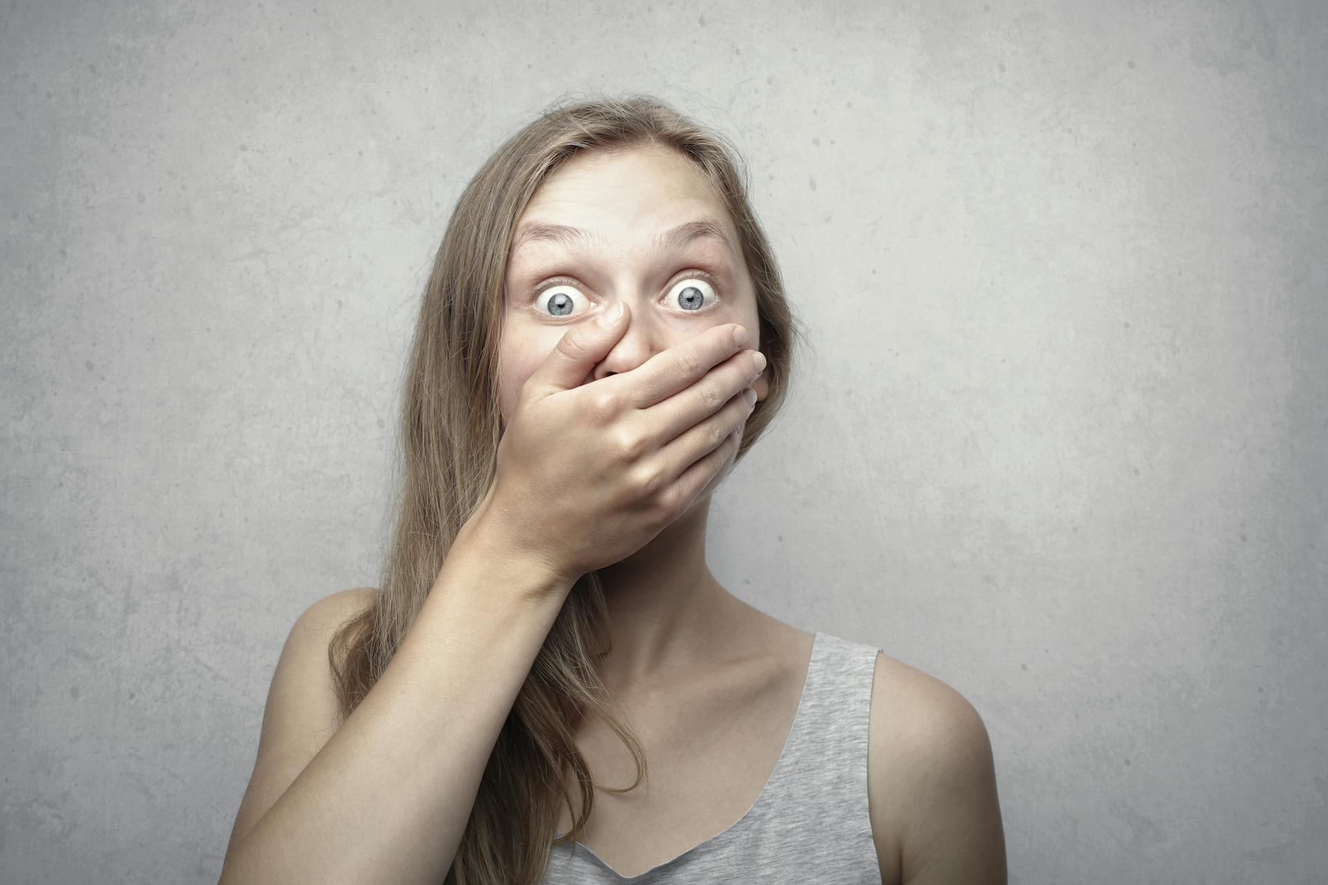 Une femme choquée se couvrant la bouche avec sa main | Source : Pexels