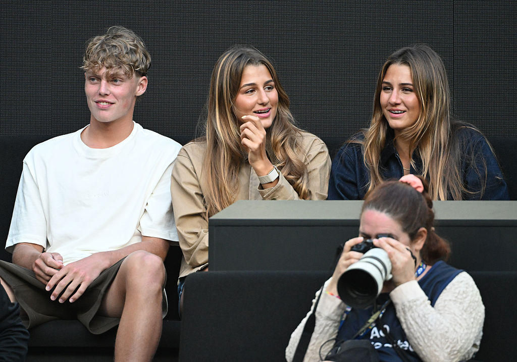 Cruz Hewitt est assis avec Myla et Charlene Federer alors qu'ils regardent Jannik Sinner (Italie) affronter Hugo Gaston (France) lors du premier tour du simple messieurs de l'Open d'Australie 2026 au Melbourne Park, le 20 janvier 2026 à Melbourne, en Australie I Source : Getty Images