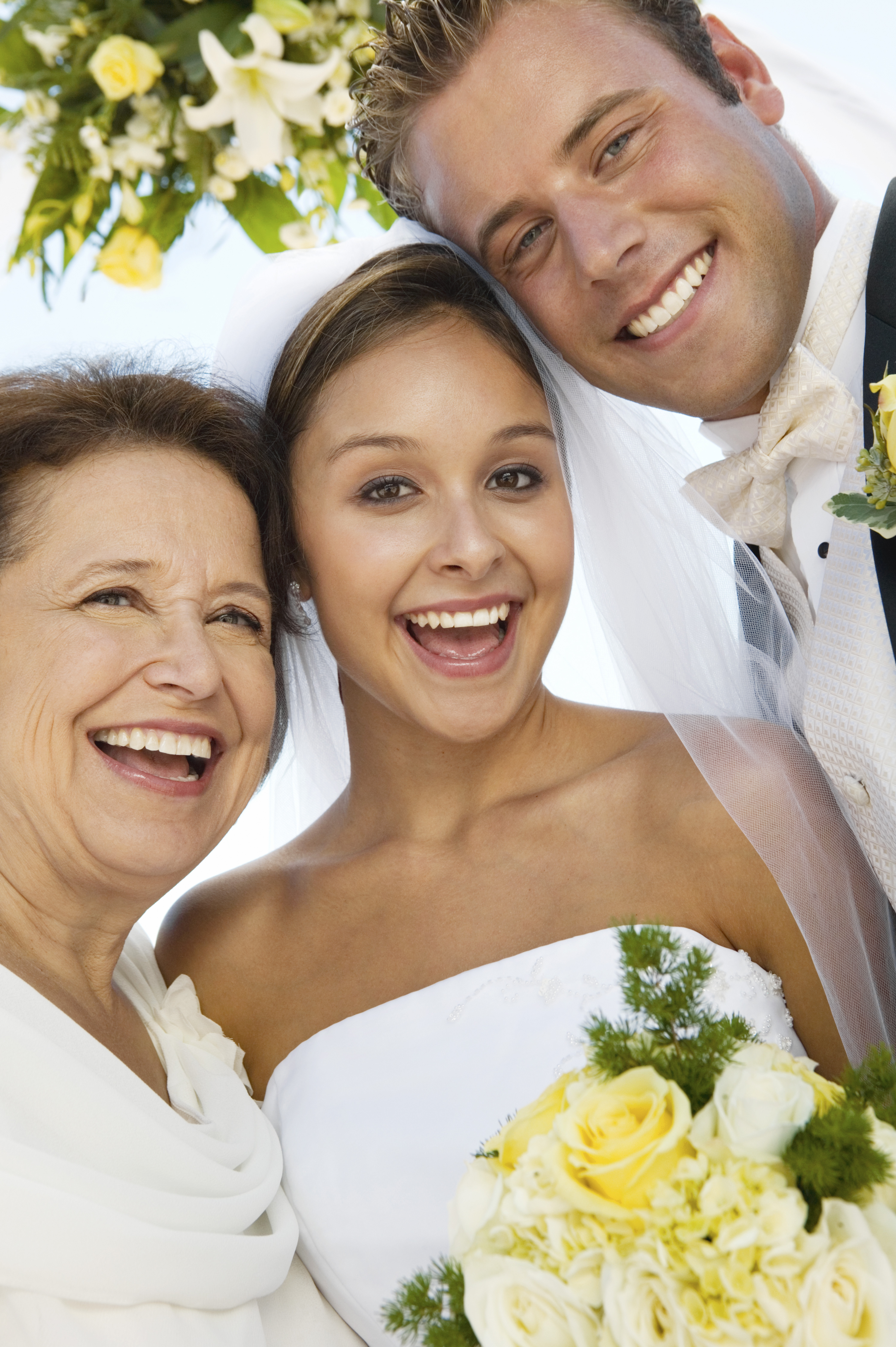 Une mariée et un marié avec leur mère le jour de leur mariage | Source : Shutterstock