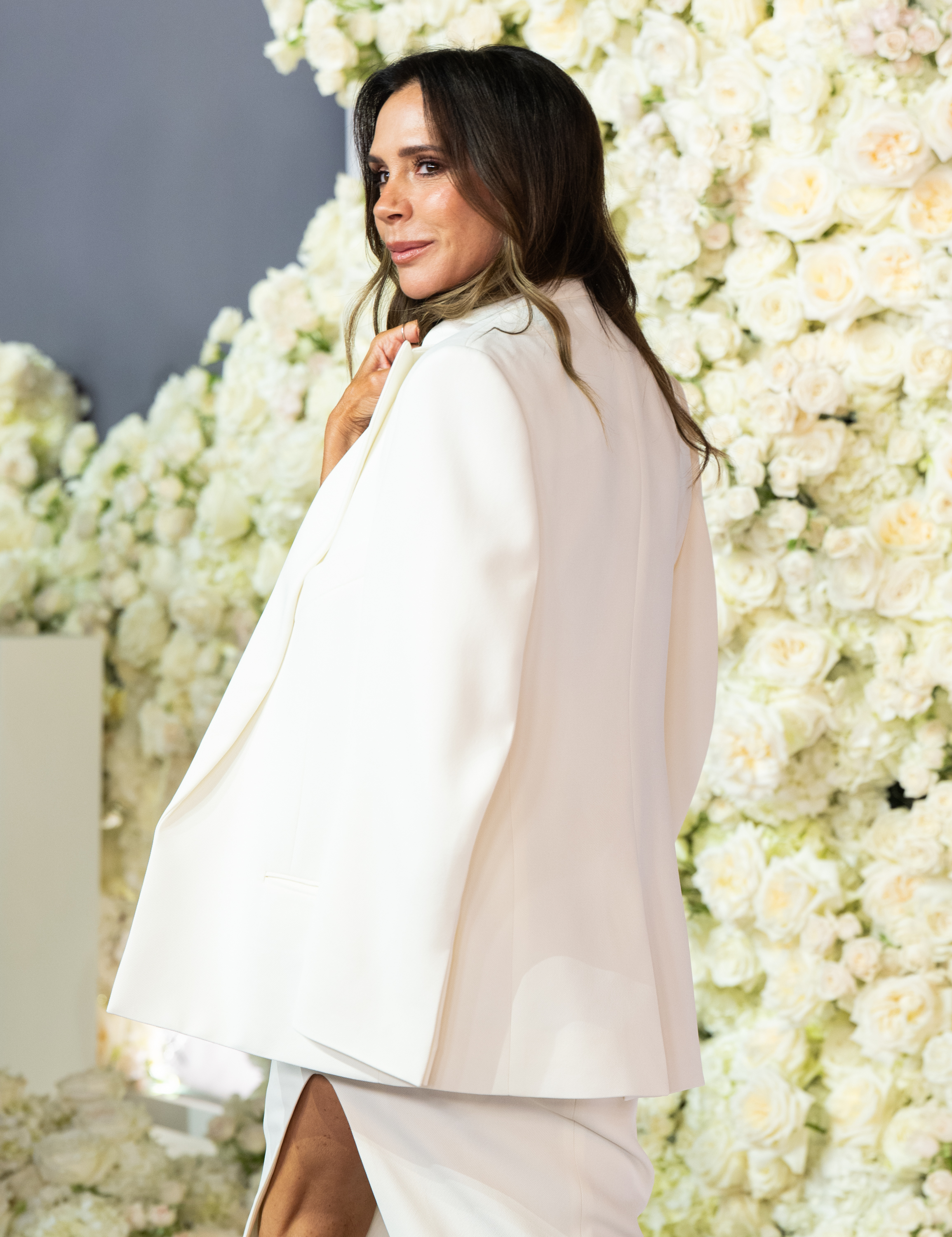 Victoria a aussi été photographiée de dos lors de grandes apparitions publiques, ce qui permet de découvrir sous un autre angle son style impeccable. Lors de la première londonienne de « Victoria Beckham » en octobre 2025, elle a posé dans une tenue blanche sur mesure, des mois avant que sa tenue de Portofino ne devienne un sujet de discussion en ligne. | Source : Getty Images