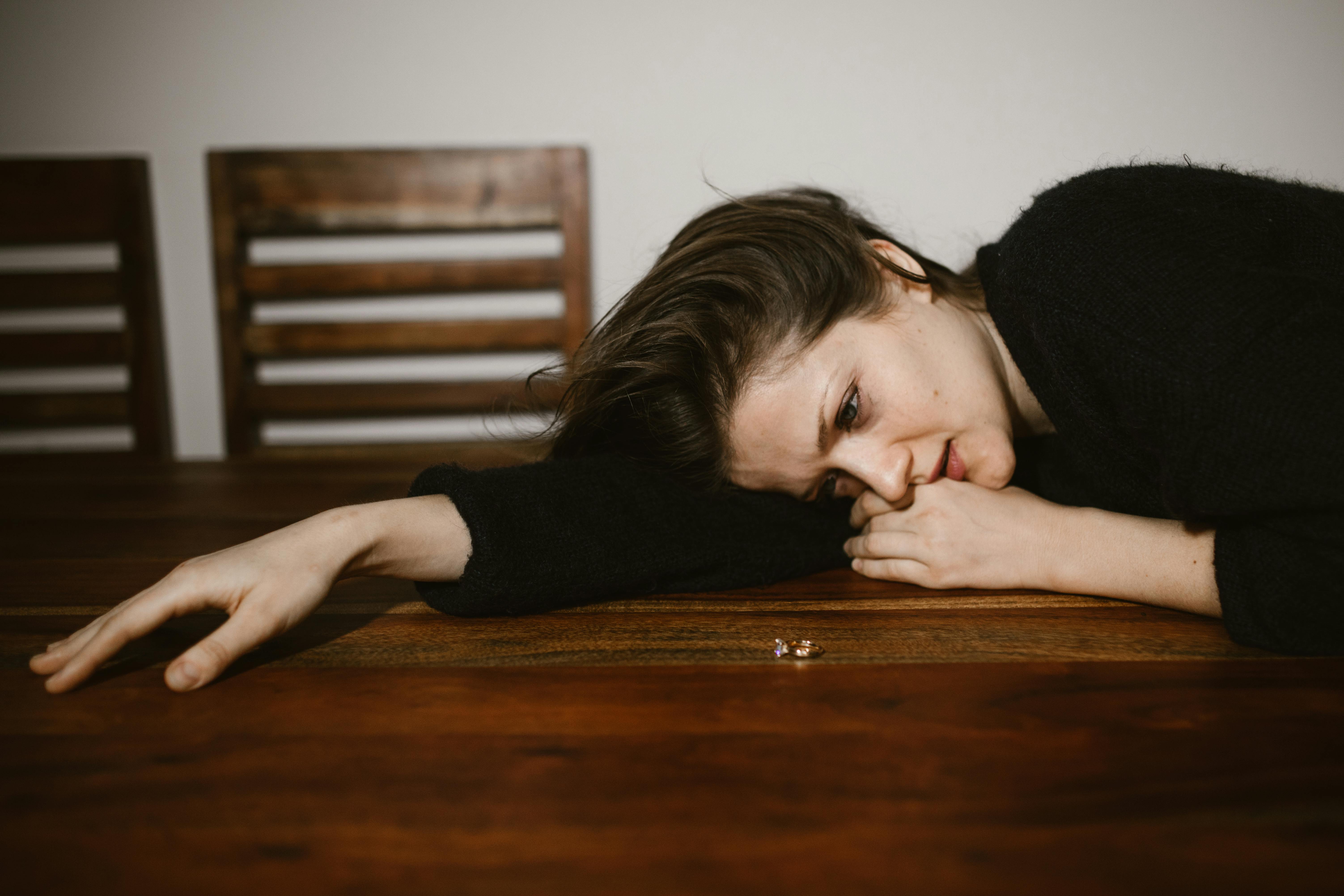 Une femme en pleurs appuyée sur une table | Source : Pexels