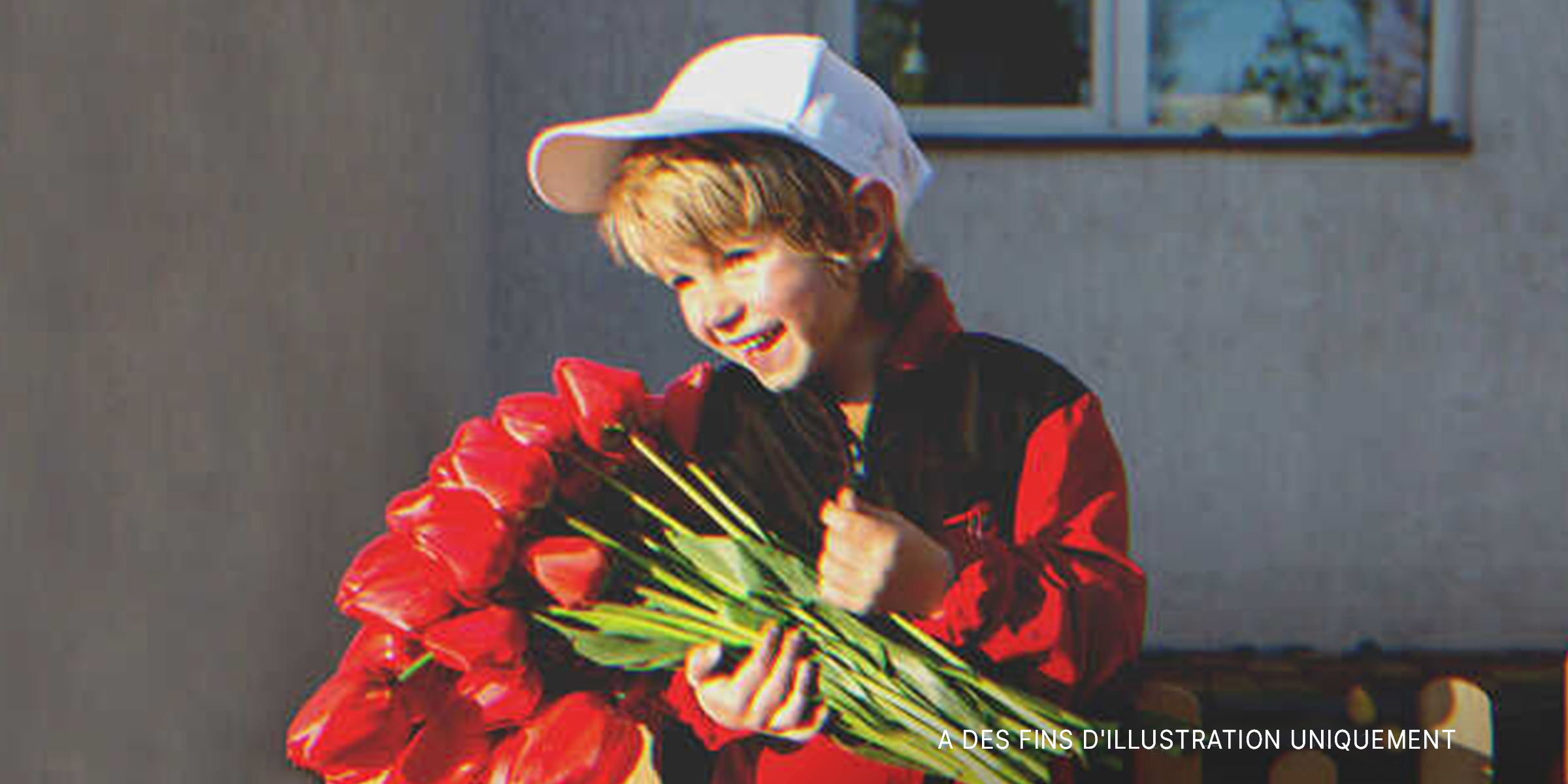 Un garçon tenant des fleurs | Source : Shutterstock