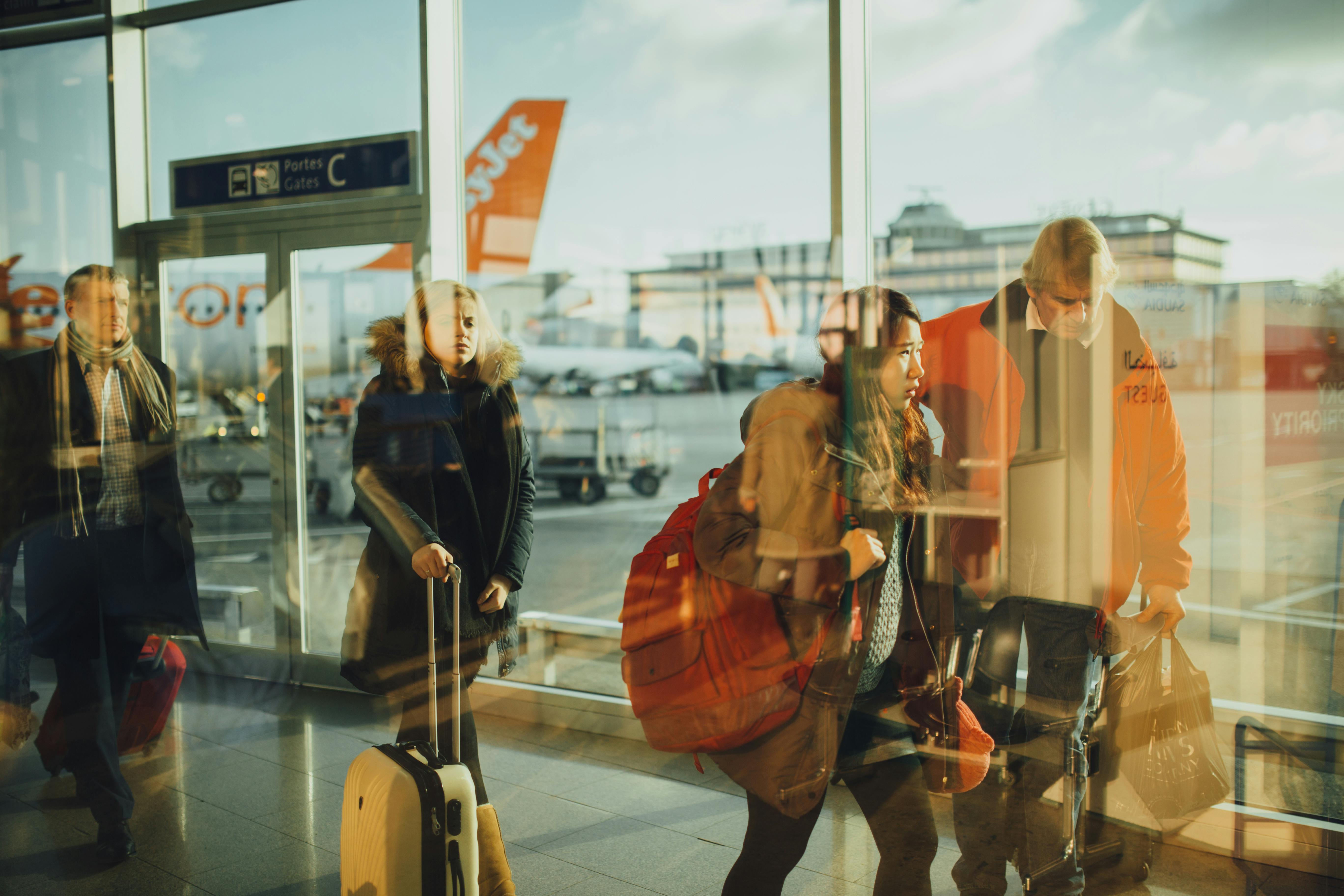 Des voyageurs se frayant un chemin dans un hall d'aéroport | Source : Pexels