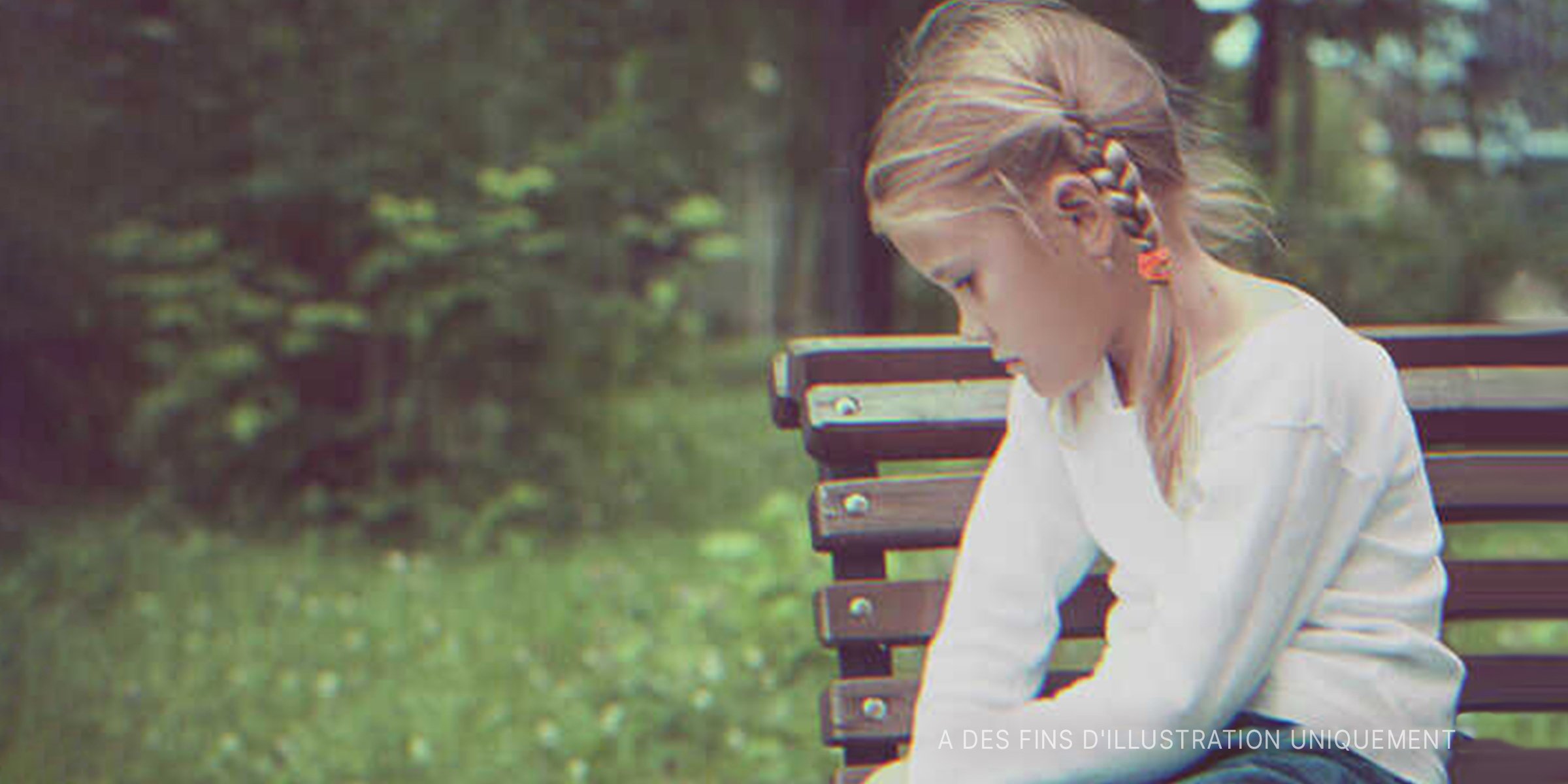 Une fille triste assise sur un banc | Source : Shutterstock