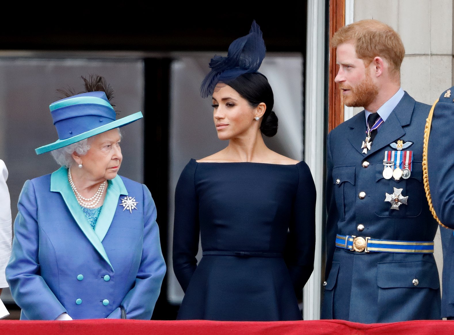 La reine Elizabeth II, Meghan, duchesse de Sussex, et le prince Harry, duc de Sussex, assistent à un défilé aérien pour marquer le centenaire de la Royal Air Force depuis le balcon du palais de Buckingham, le 10 juillet 2018 à Londres, en Angleterre | Source : Getty Images