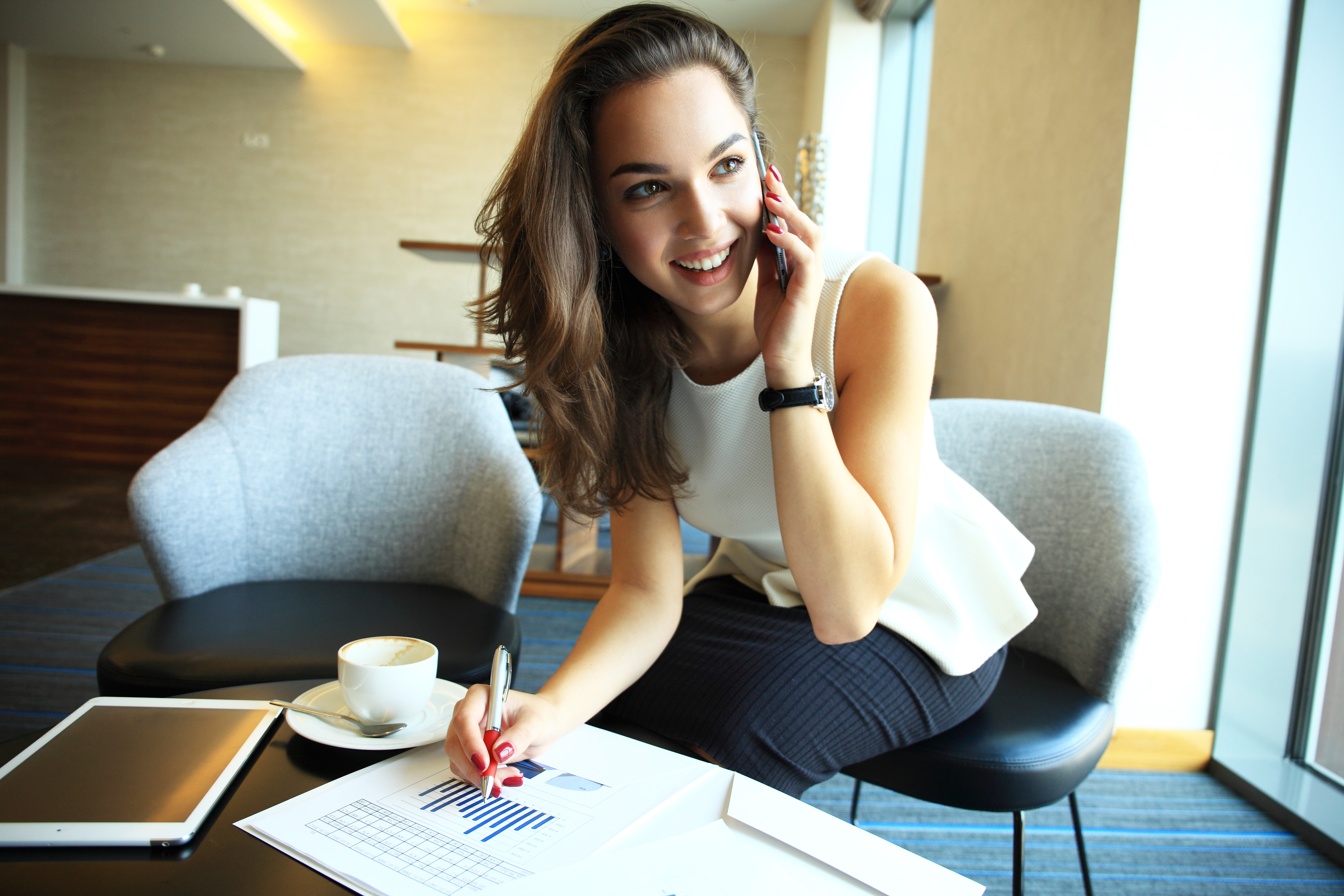Une femme qui parle au téléphone tout en écrivant quelque chose | Source : Shutterstock