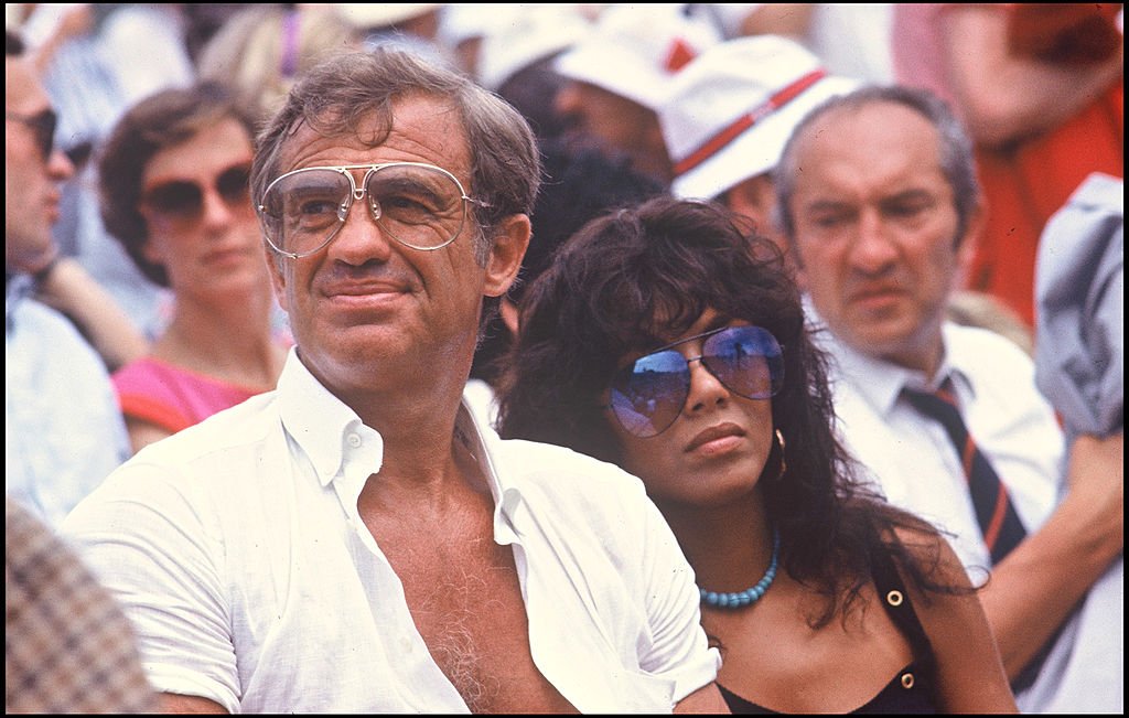 Jean-Paul Belmondo et sa petite amie Carlos Sotto Mayor à Roland Garros, 1982. | Photo : Getty Images