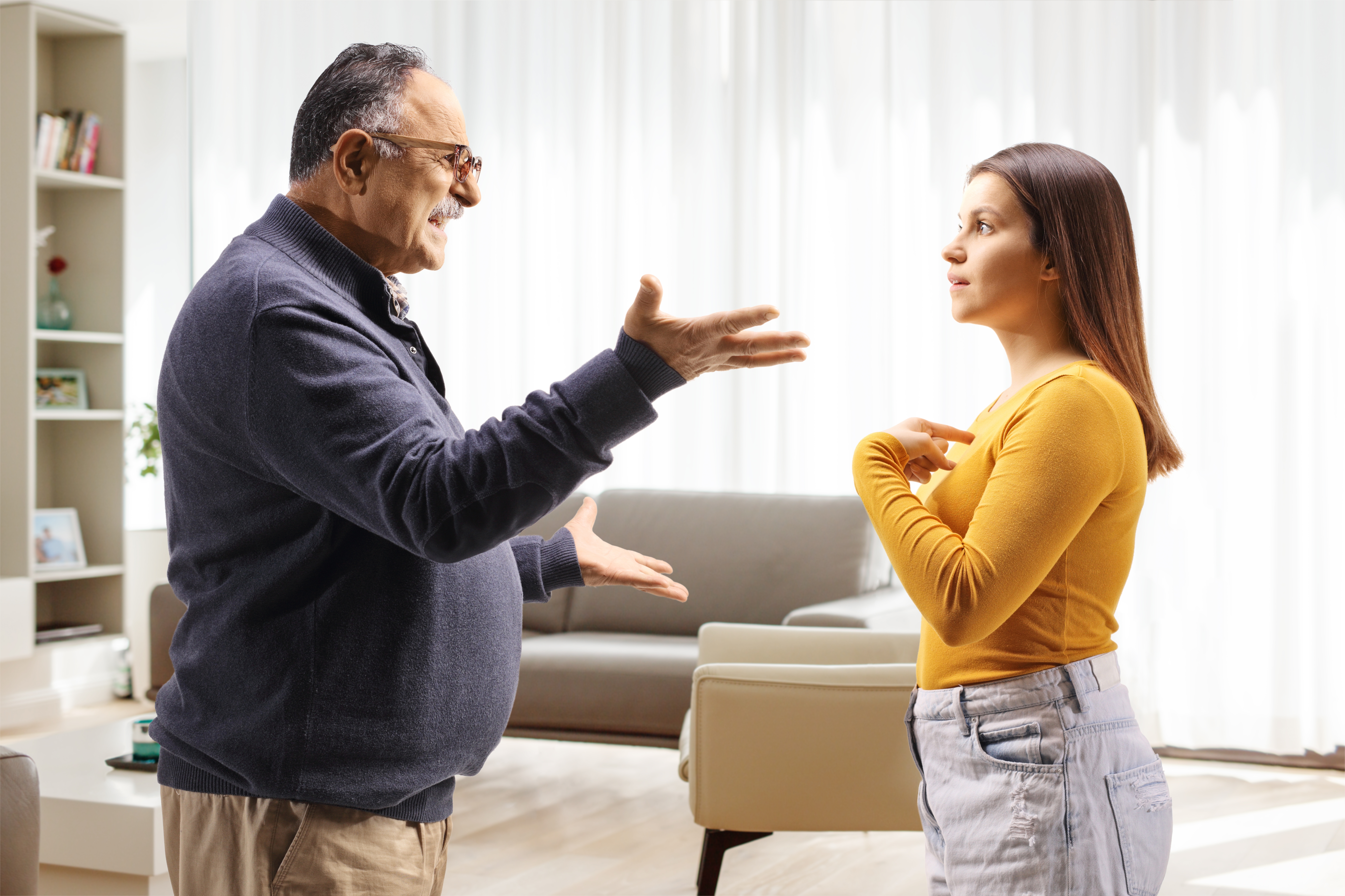 Un père et sa fille se disputent dans le salon | Source : Shutterstock